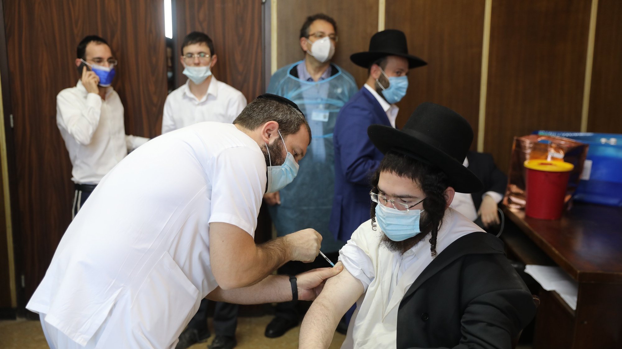 epa09004309 An Ultra orthodox Jewish man receives a COVID-19 vaccine from a nurse at Ichilov Medical Center in a Yeshiva at the Ultra orthodox city of Bnei Brak, Israel, 11 February 2021. Israel begin a vaccinations campaign at the ultra orthodox community, as Israel has so far vaccinated over three million of its around nine million citizens with the first dose of the coronavirus and two million have been given the second dose  EPA/ABIR SULTAN