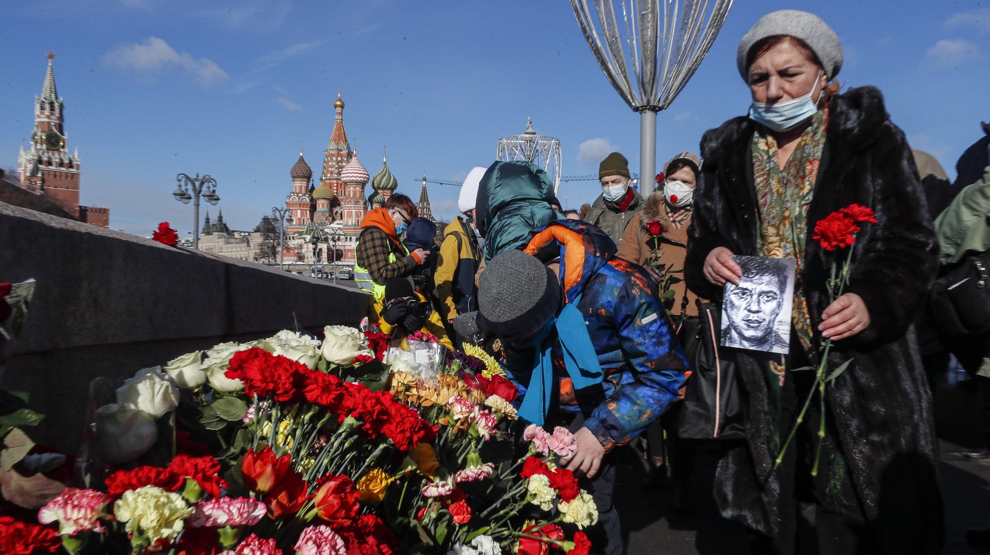 epa09039796 People lay flowers at the site where Russian opposition politician Boris Nemtsov died during an event marking the sixth anniversary of his assassination, in Moscow, Russia, 27 February 2021. Boris Nemtsov was killed on 27 February 2015 by suspected Chechen hitmen on a bridge in front of the Kremlin.  EPA/SERGEI ILNITSKY
