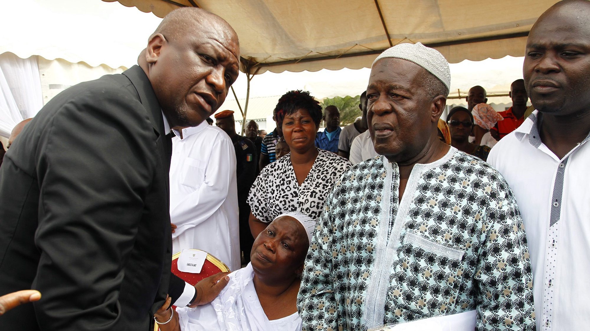 epa05249727 Ivorian minister of security and interior Hamed Bakayoko (L) comforts parents of victims who lost lives in the Grand Bassam beach attack during a ceremony to honour the victims in Abidjan, Ivory Coast, 08 April 2016. According to reports, fourteen civilians and six assailants were killed on 13 March 2016 when gunmen opened fire on guests on the beach at the Etoile du Sud hotel in the town of Grand Bassam which is popular with foreigners. Al-Qaeda in the Islamic Maghreb (AQIM) claimed responsibility for the attack. Among those killed were a French and German national.  EPA/LEGNAN KOULA