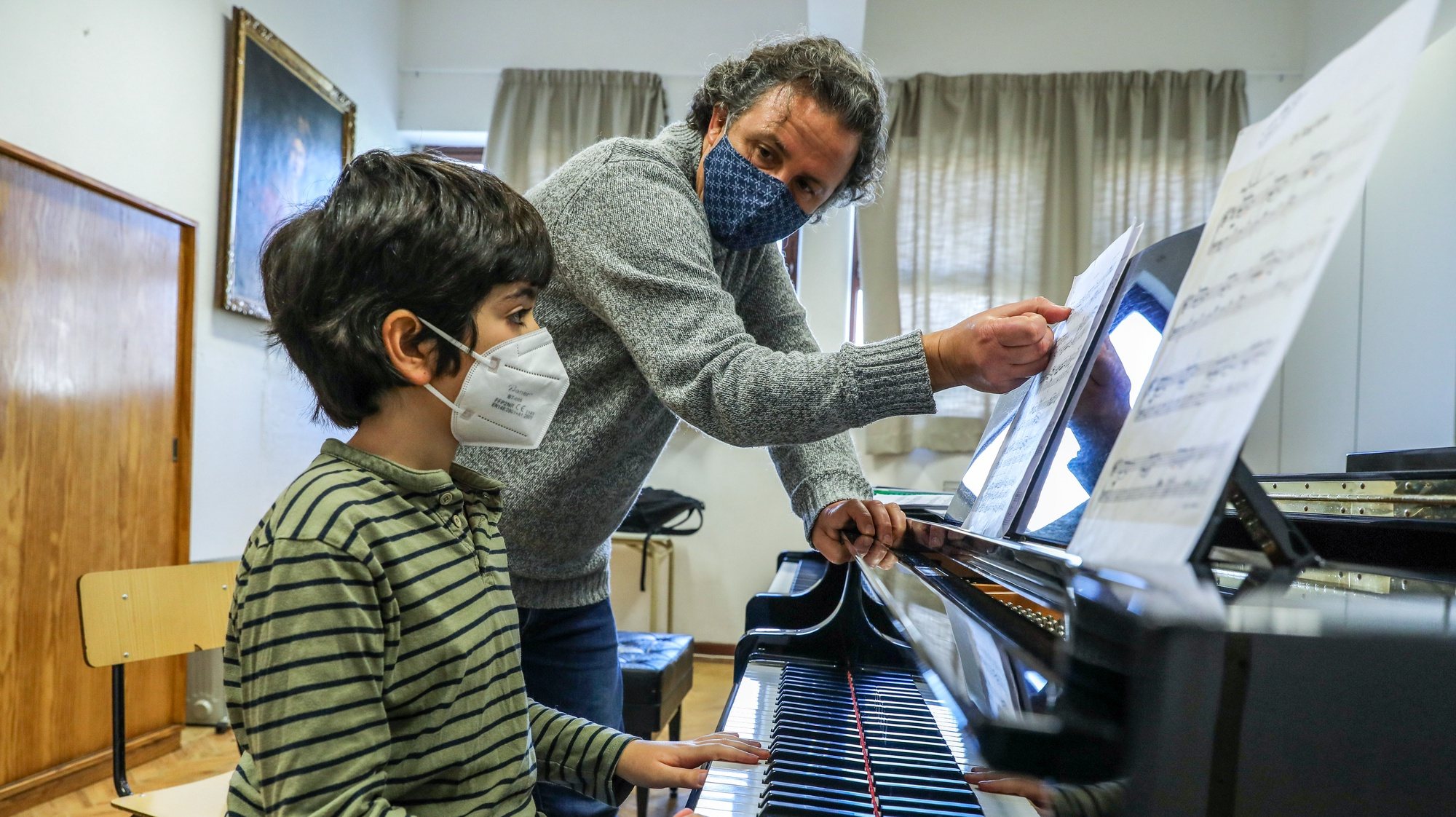 Um professor de música dá aulas presenciais de piano a um aluno nas instalações provisórias na Escola Secundária Marquês de Pombal, em Lisboa, onde decorrem aulas presenciais do Conservatório Nacional de Música, 10 de março de 2021. (ACOMPANHA TEXTO DA LUSA DO DIA 14 DE MARÇO DE 2021). MIGUEL A. LOPES/LUSA