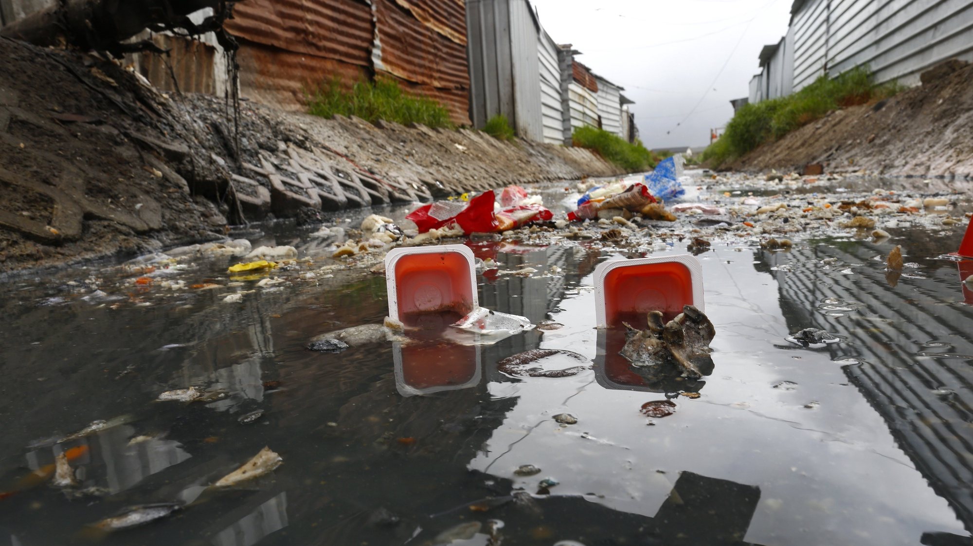 epa06602747 A general view of garbage in a highly polluted river next to shack homes in Masiphumelele, Cape Town, South Africa, 14 March 2018. Rapid urbanization and a national government that has not provided enough infrastructure in high density neighborhoods like Masiphuumelele are two of the major factors environmentalists cite contributing to the polluting of urban rivers. Environmental activists globally observe on 14 March annually the International Day of Action for Rivers with the aim of raising awareness around issues concerning the world&#039;s water ways.  EPA/NIC BOTHMA