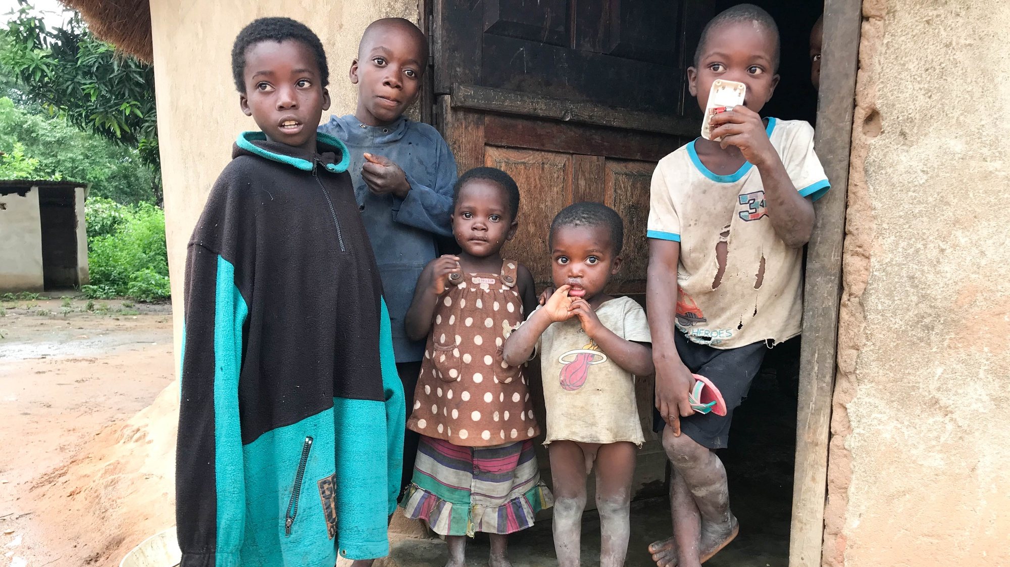 Irmãos de Rutendo Djambo (ausente da fotografia), à porta de casa na aldeia de Nhandiro, Mavonde, no interior de Manica, Moçambique, 17 de fevereiro de 2021. Um total de 92 crianças foram identificadas pelos 114 Comités Comunitários de Proteção a Criança, criados pela Save The Children, como estando em situação de risco de uniões prematuras em 2020 nos distritos de Manica, Machaze, Macossa e Tambara, tendo 47 sido resgatadas. (ACOMPANHA TEXTO DA LUSA DO DIA 01 DE MARÇO DE 2021). ANDRÉ CATUEIRA/LUSA