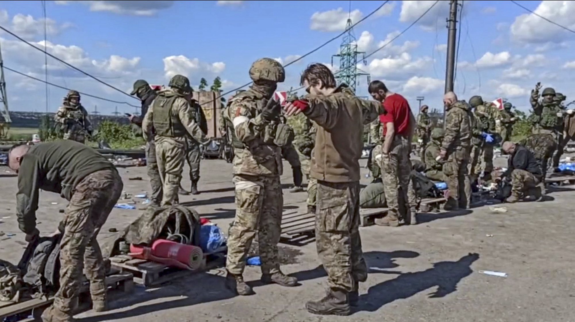 epa09962236 A still image taken from handout video made available on 21 May 2022 by the Russian Defence Ministry&#039;s press service shows Russian servicemen frisking Ukrainian servicemen evacuated from the besieged Azovstal steel plant in Mariupol, Ukraine, 20 May 2022 (issued 21 May 2022). The Chief spokesman of the Russian Defense Ministry, Major General Igor Konashenkov, said on 20 May that the Azofstal steel plant is now under full Russian army control. Russian troops entered Ukraine on 24 February 2022.  EPA/RUSSIAN DEFENCE MINISTRY PRESS SERVICE/HANDOUT BEST QUALITY AVAILABLE HANDOUT EDITORIAL USE ONLY/NO SALES