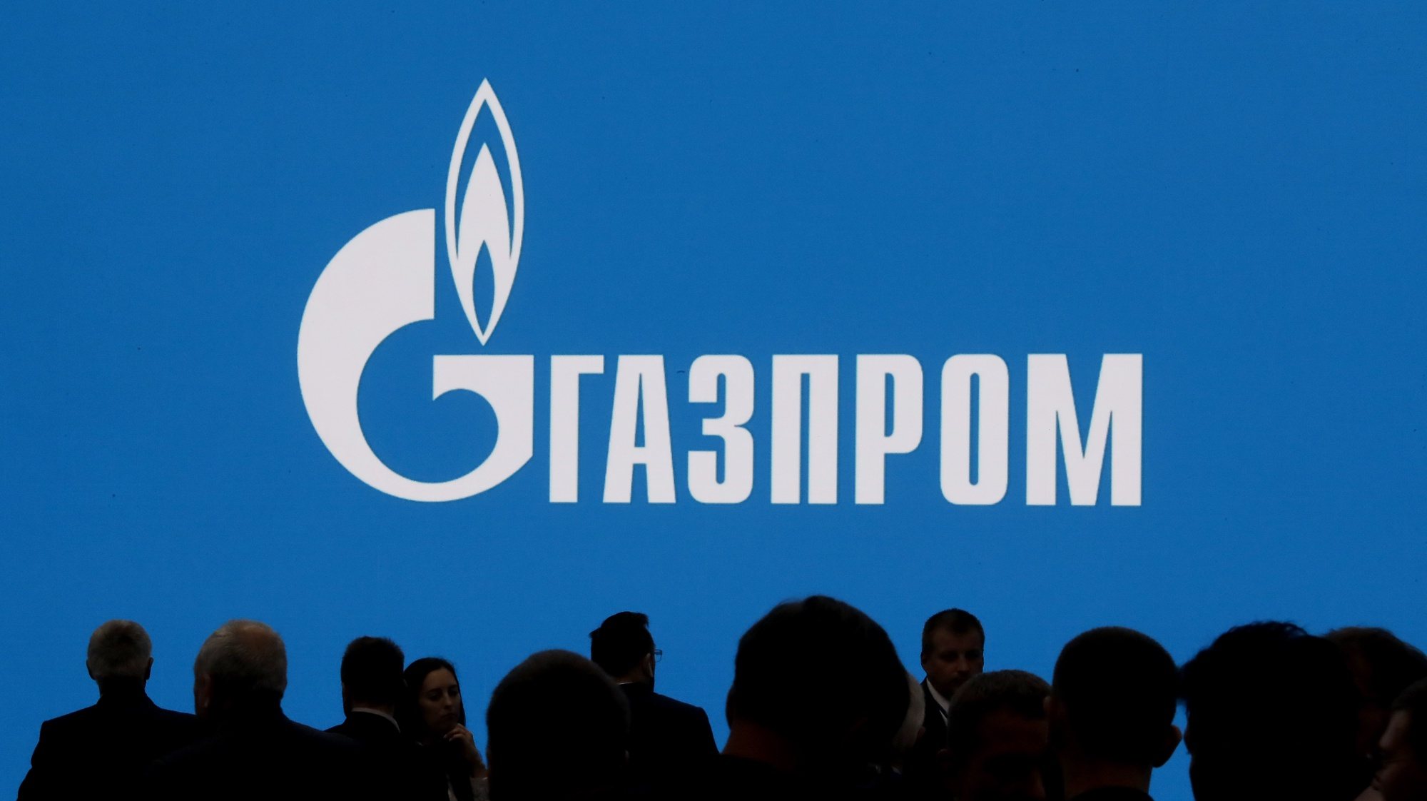 epaselect epa10181738 People walk in front of a large screen shows Gazprom Company logo at the St. Petersburg International Gas Forum (SPIGF) in St. Petersburg, Russia, 13 September 2022. The 11th St.Petersburg International Gas Forum runs from 13 to 16 September 2022.  EPA/ANATOLY MALTSEV