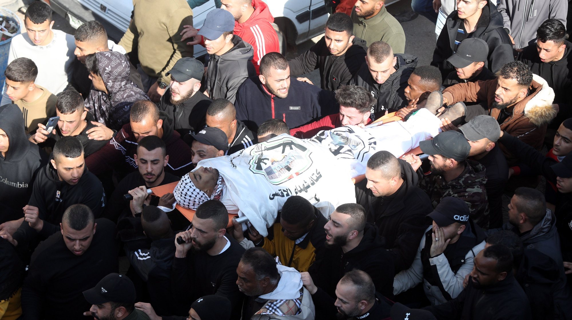 epa10431327 Mourners carry a body of one of nine Palestinians killed during clashes with Israeli troops in Jenin, West Bank, 26 January 2023. At least nine Palestinians were killed, including an elderly woman, during clashes in Jenin on 26 January, according to the Palestinian Health Ministry. Israeli security forces said they conducted a &#039;counterterrorism operation&#039; in the center of Jenin.  EPA/ALAA BADARNEH