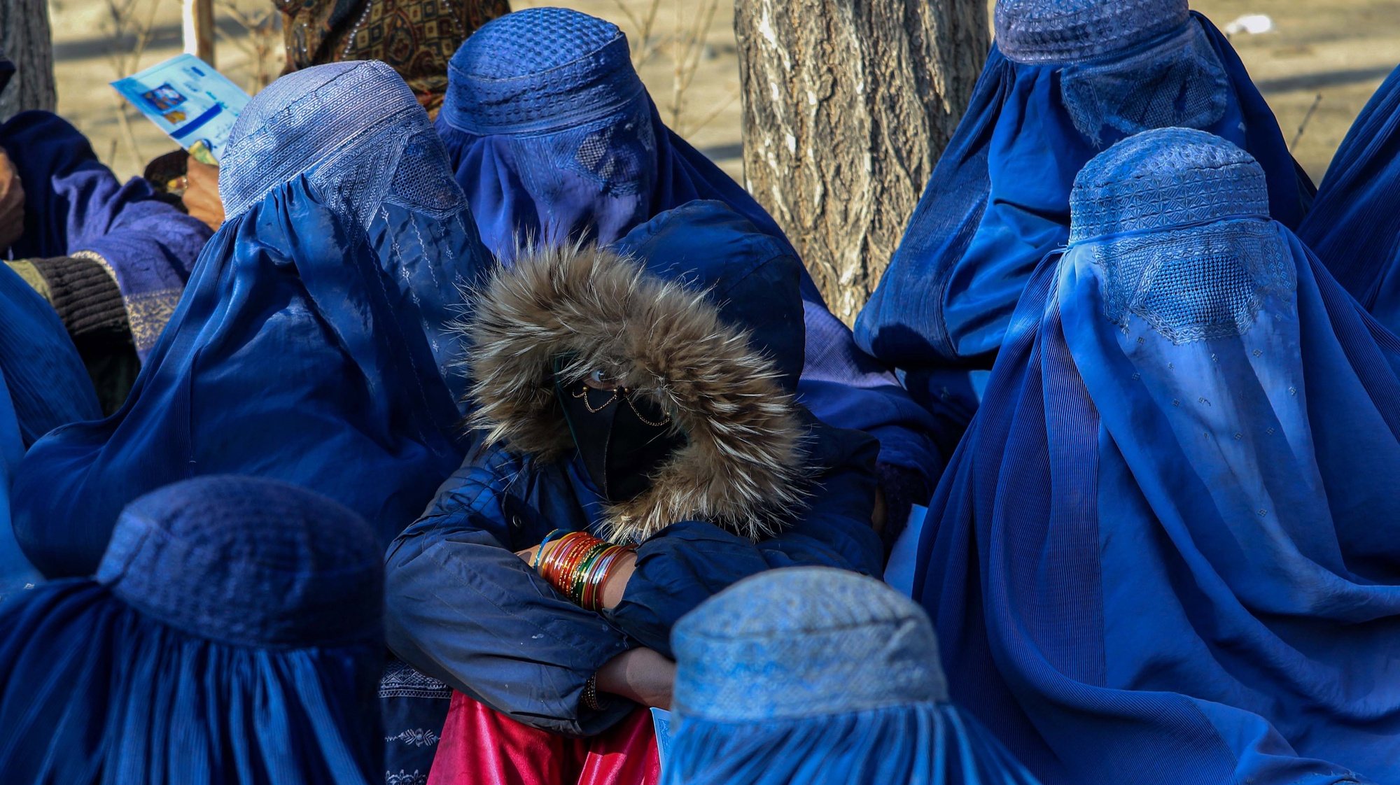 epa10411530 Afghan women wait to receive food and coal distributed by Bashir Navid Group in Kabul, Afghanistan, 17 January 2023. These aid packages include a sack of coal, a sack of 50 kg flour and a five liter bottle of oil.  EPA/STRINGER