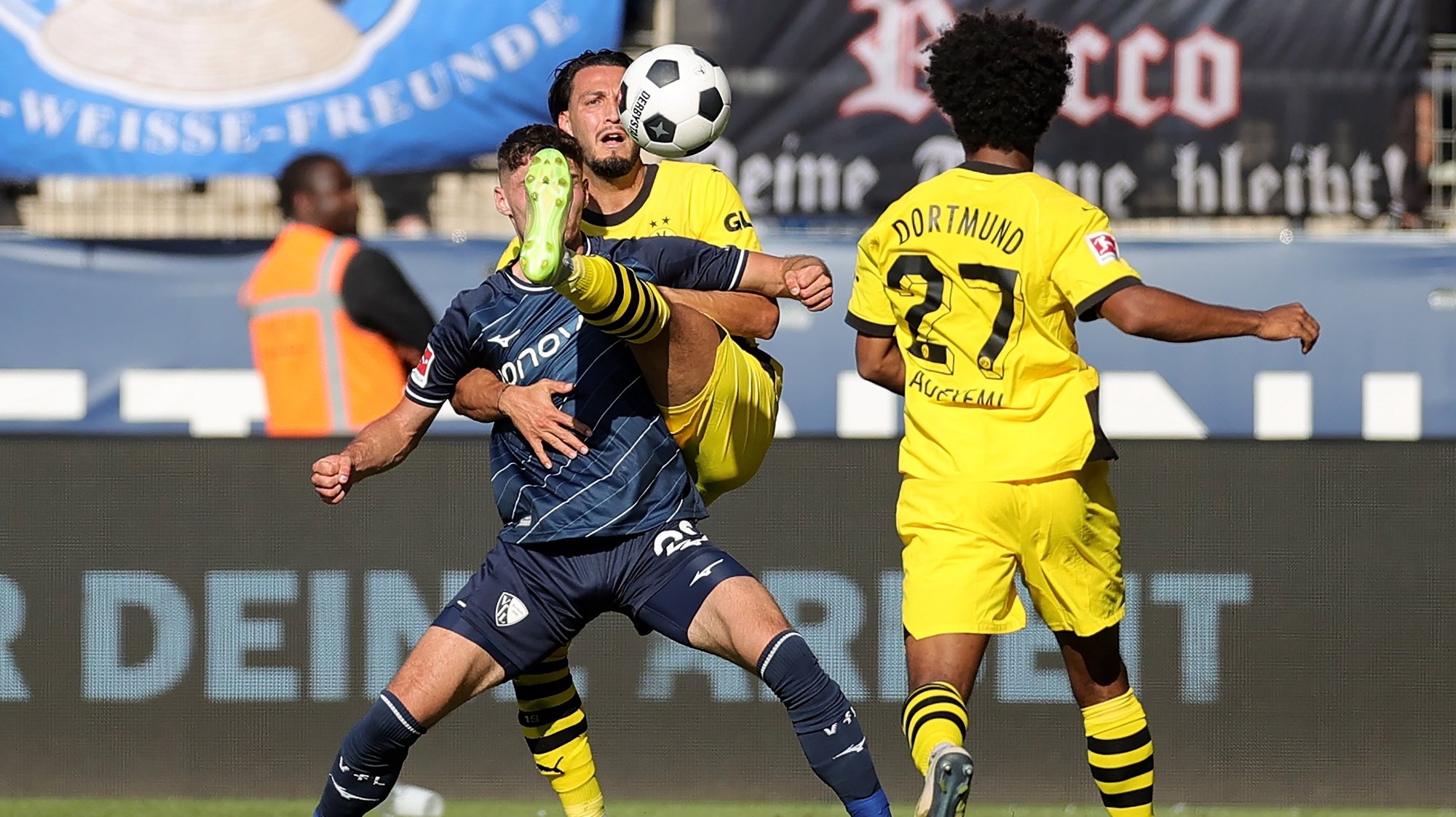 epa10821750 Bochum&#039;s Moritz Broschinski (L) in action against Dortmund&#039;s Ramy Bensebaini (C) during the German Bundesliga soccer match between VfL Bochum and Borussia Dortmund in Bochum, Germany, 26 August 2023.  EPA/FRIEDEMANN VOGEL CONDITIONS - ATTENTION: The DFL regulations prohibit any use of photographs as image sequences and/or quasi-video.