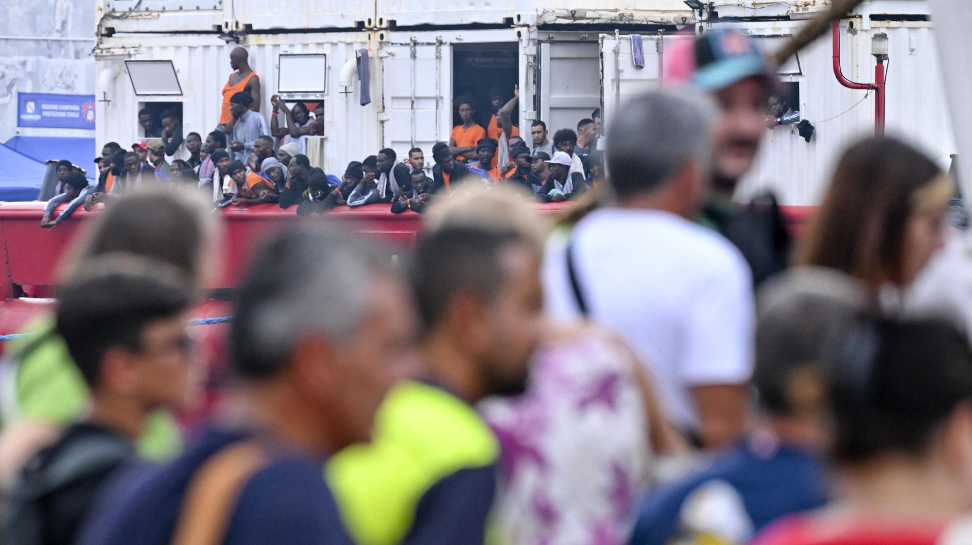 epa10824952 Migrants aboard the &#039;Ocean Viking&#039;, the SOS Mediterranee ship that rescued 439 migrants between Lampedusa and Tunisia, look on as they arrive in the port of Naples, Italy, 28 August 2023.  EPA/CIRO FUSCO