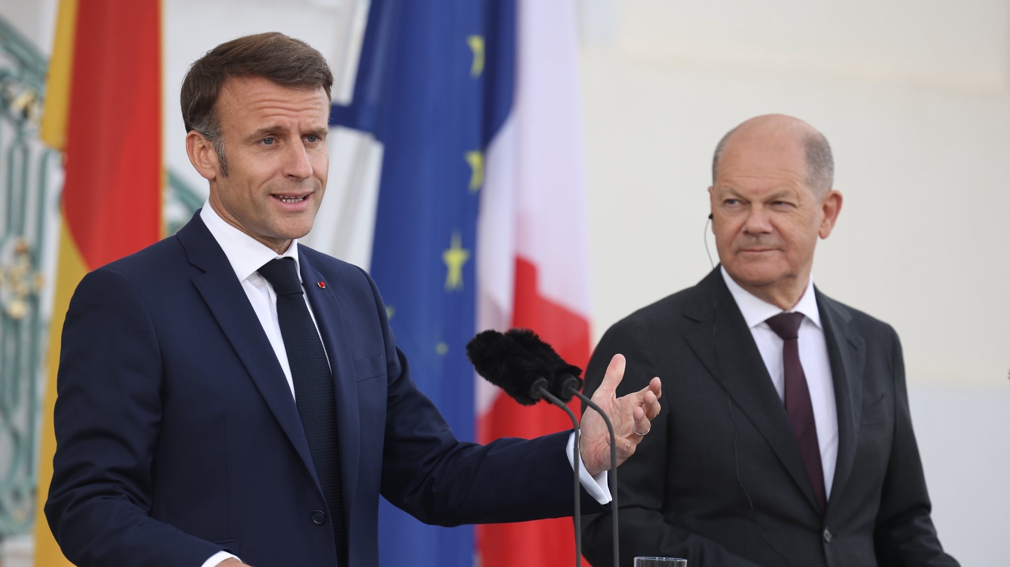 epa11375932 French President Emmanuel Macron (L) gestures next to German Chancellor Olaf Scholz during a joint press conference at Meseberg Palace in Meseberg near Gransee, Germany, 28 May 2024. French President Emmanuel Macron visits Germany from 26 to 28 May. After appointments with Federal President Steinmeier in German regions Berlin, Dresden and Muenster, Macron meets German Chancellor Olaf Scholz at Meseberg Palace on 28 May 2024 for a Franco-German Council of Ministers.  EPA/CLEMENS BILAN
