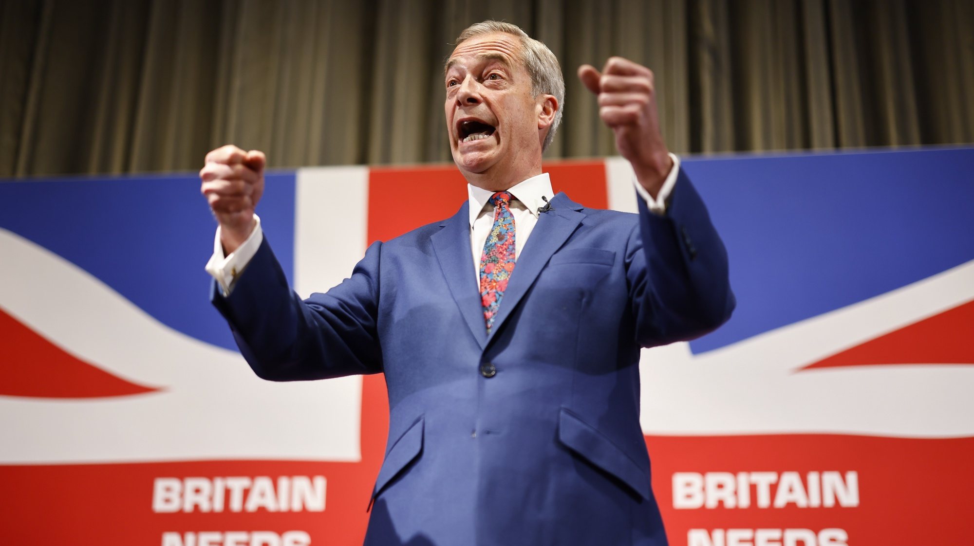 epaselect epa11379338 Honorary President of Reform UK Nigel Farage gestures while speaking at a press conference for the Reform UK party at the Glaziers Hall, London, Britain, 30 May 2024. Britain will hold a snap general election on 04 July 2024.  EPA/TOLGA AKMEN