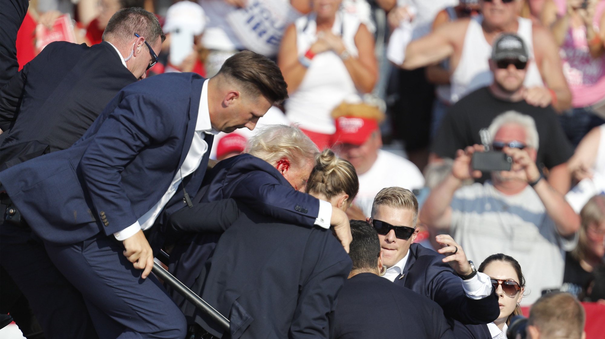 epa11476773 Former US President Donald Trump is rushed from the stage by secret service after an incident during a campaign rally at the Butler Farm Show Inc. in Butler, Pennsylvania, USA, 13 July 2024. According to a statement by a secret service spokesperson, the former President is safe and further information on the incident will be released when available.  EPA/DAVID MAXWELL
