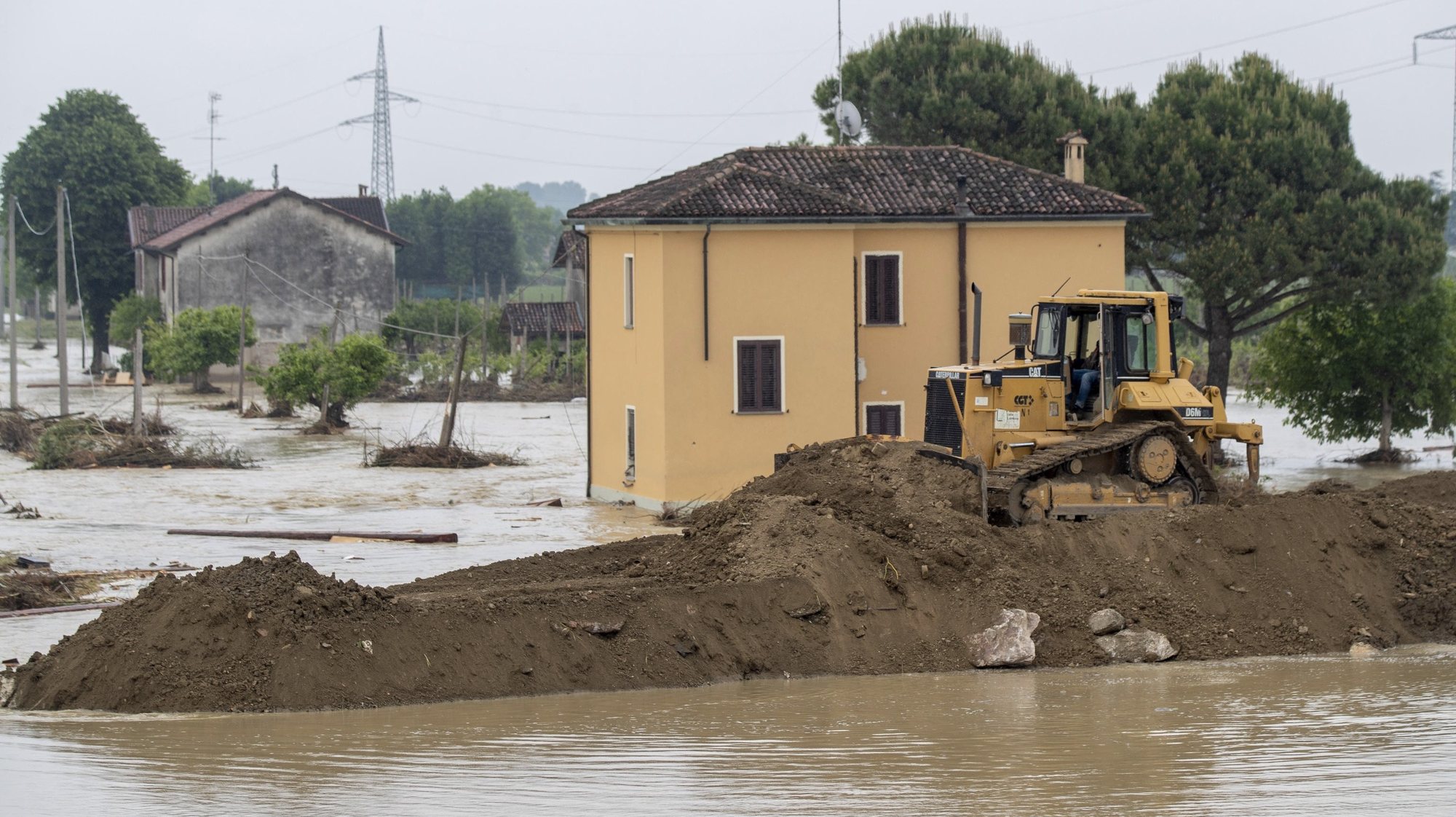 epa10641403 An excavator tries to rebuild embankment of the Sillaro river after it broke the embankment, destroying a house and flooded the town in attempt to block the water that is flooding the surrounding countryside, in Lugo, Emilia-Romagna region, Italy, 20 May 2023.  The death toll from this week&#039;s deadly flooding in Emilia Romagna has climbed to 14. The northeastern region will remain on red alert on 20 May with more rain forecast. Among other things, the risk of landslides is considered particularly high. The number of people who have had to leave their homes because of the flooding in Emilia-Romagna has risen to over 15,000, the regional government said on 19 May.  EPA/BOVE-ZANI