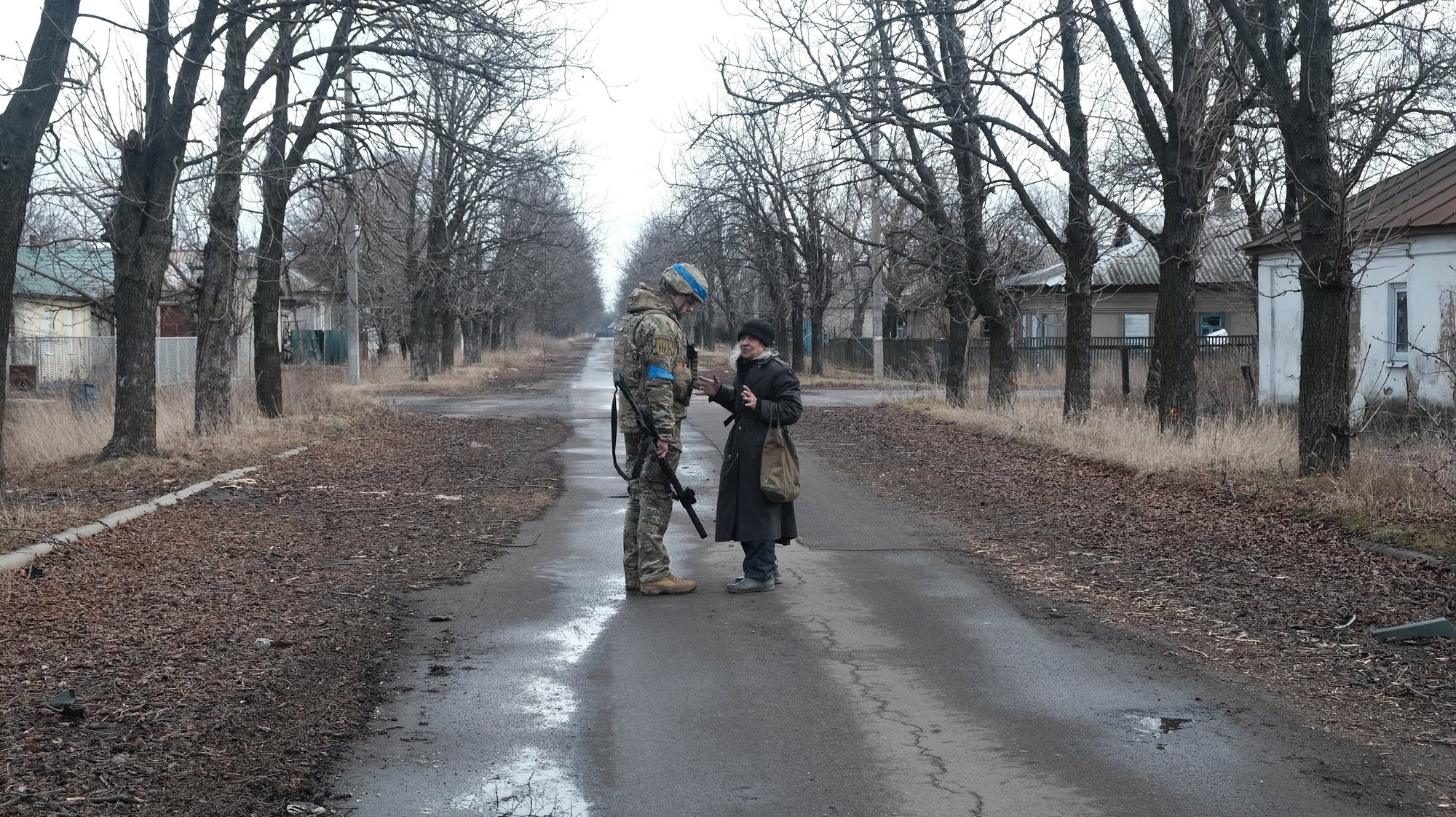 epa10507971 A Ukrainian soldier from the Volyn Detachment speaks to a civilian as he patrols the devastated town of Velyka Novosilka, Donetsk region, Ukraine, 07 March 2023. There are less than 500 people still living in the town, because the Russian positions are less than a kilometer away and the shelling is continuous. Russian troops entered Ukrainian territory on 24 February 2022, starting a conflict that has provoked destruction and a humanitarian crisis.  EPA/MARIASENOVILLA