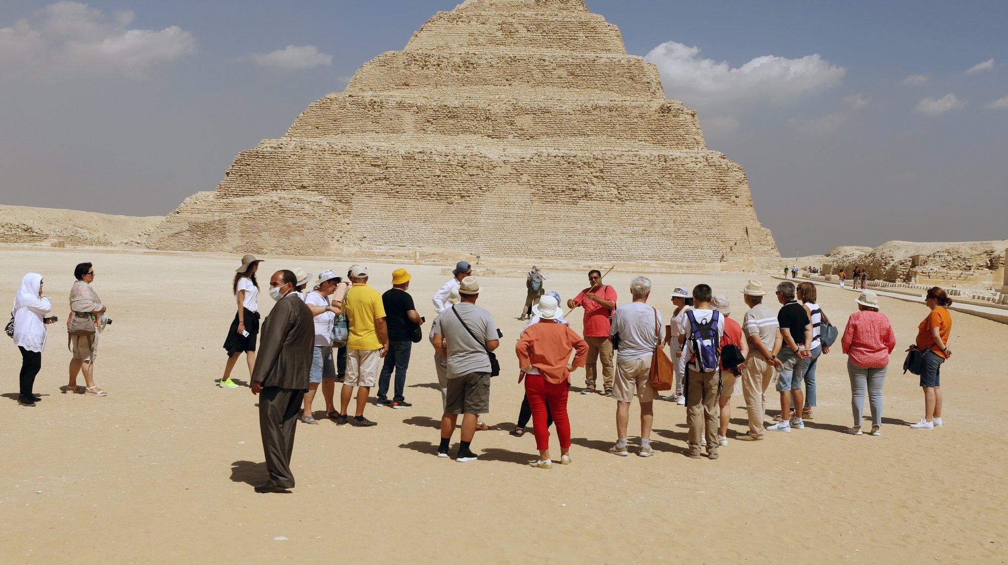 epa09467606 A group of tourists gathers outside Tomb of King Djoser step pyramid, that was reopened for visitors after a restoration, in the Saqqara area, near Giza, Egypt, 14 September 2021. An information plate by the Ministry of Tourism &amp; Antiques at the entrance of the site describes the ancient Southern Tomb step pyramid, also known as the Saqqara pyramid, as being &#039;the oldest stone building of the ancient world&#039; which was &#039;discovered by the English archaeologist Cecil Malaby Firth in 1928.&#039; A series of corridors with even some false doors are described as the &#039;most important architectual and decorative elements&#039; in the tomb that also features a 7.5 x 7.5m burial chamber at a depth of some 31 meters with a sarcophagus made of 16 blocks of pink granite and a height of about 3.6 meters.  EPA/KHALED ELFIQI  HANDOUT EDITORIAL USE ONLY/NO SALES