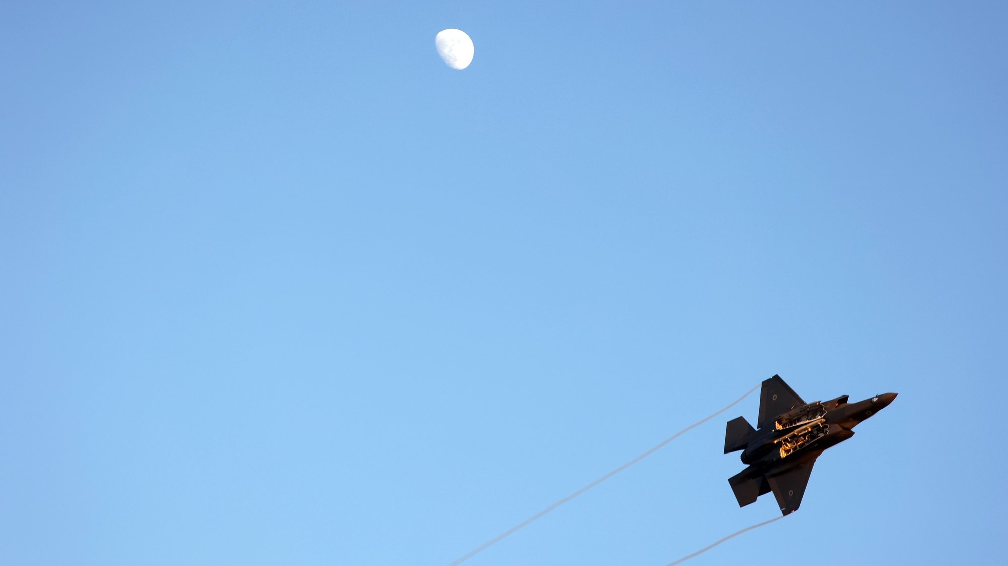 epa10717822 Israeli Air Force F-35  fighter aircraft flies next to the moon during an air show at the graduation ceremony of new combat fighter pilots of the Israeli Air Forces at the Hatzerim Air Force base, outside Beersheva, in southern Israel, 29 June 2023.  EPA/ABIR SULTAN