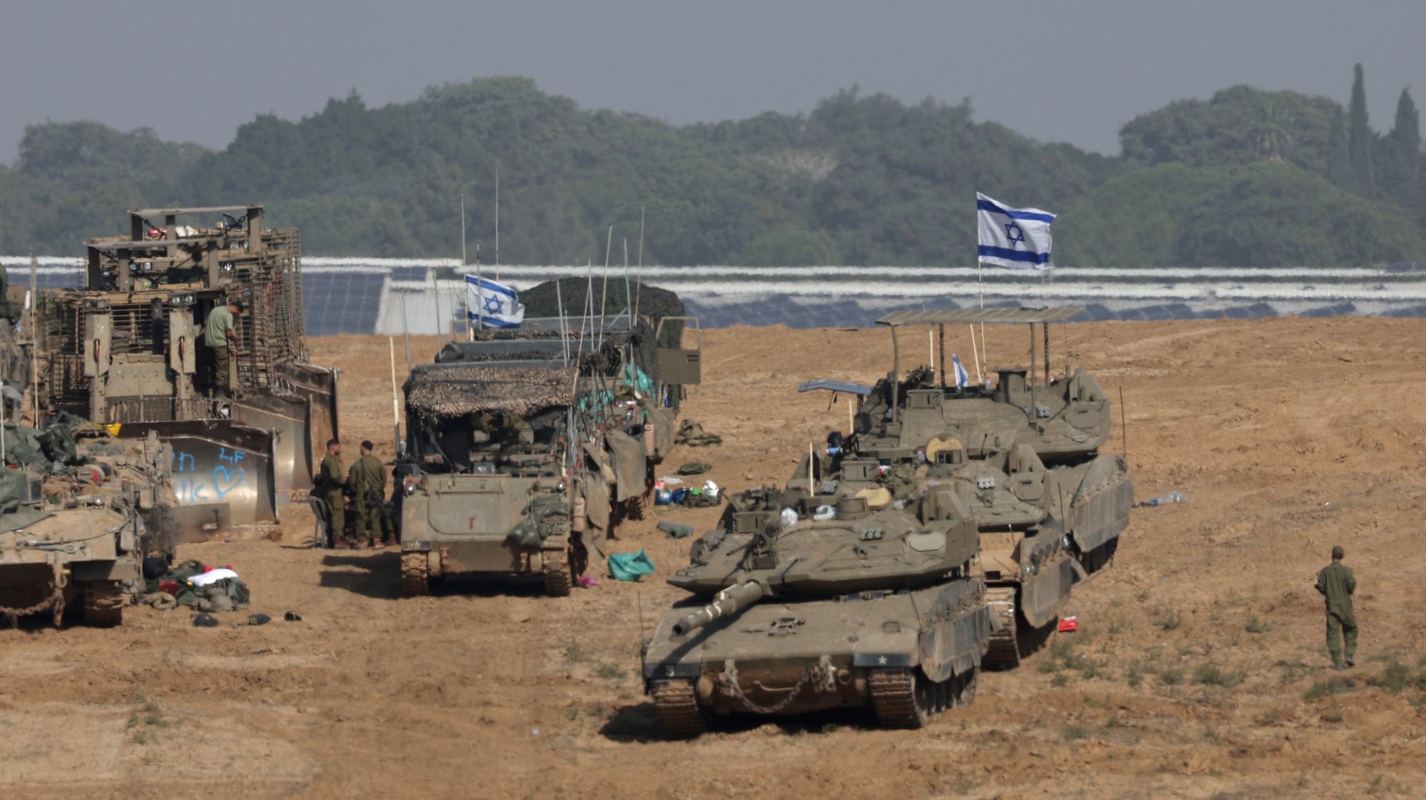 epa11007081 Israeli soldiers with their armoured fighting vehicles gather at a position near the border with the Gaza Strip, in southern Israel, 02 December 2023. The IDF announced on 02 December they struck over 400 targets throughout the Gaza Strip over the past day, adding that Israeli Air Force (IAF) fighter jets struck over 50 targets in the Khan Yunis area overnight. Israeli forces hit targets in the Gaza Strip after a week-long truce expired on 01 December. More than 15,000 Palestinians and at least 1,200 Israelis have been killed, according to the Gaza Government media office and the Israel Defense Forces (IDF), since Hamas militants launched an attack against Israel from the Gaza Strip on 07 October, and the Israeli operations in Gaza and the West Bank which followed it.  EPA/ATEF SAFADI