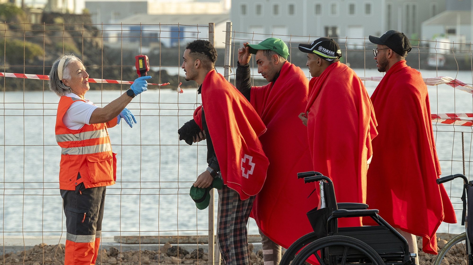 epa10975770 A Red Cross paramedic checks migrants as they arrive to Arrecife port in Lanzarote, Canary Islands, Spain, 15 November 2023. A total of 83 migrants traveling on board two toy boats were rescued at sea as they were trying to reach the Spanish coasts.  EPA/Adriel Perdomo