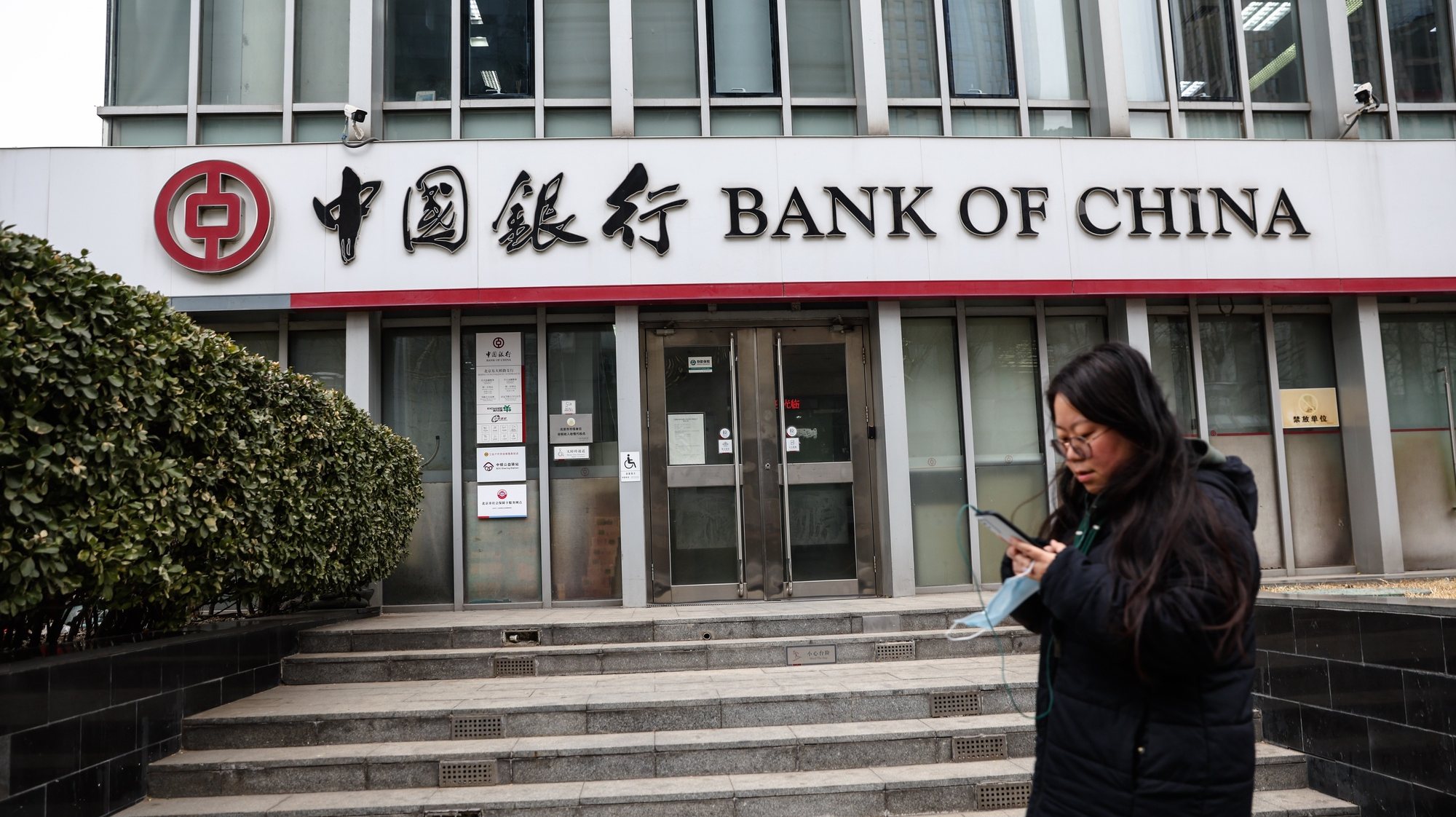 epa11167191 A woman walks beside a bank in Beijing, China, 20 February 2024. China&#039;s one-year loan prime rate was unchanged at 3.45 percent, while the five-year benchmark loan rate was decreased to 3.95 percent in February from 4.20 percent in January, the People&#039;s Bank of China said.  EPA/WU HAO