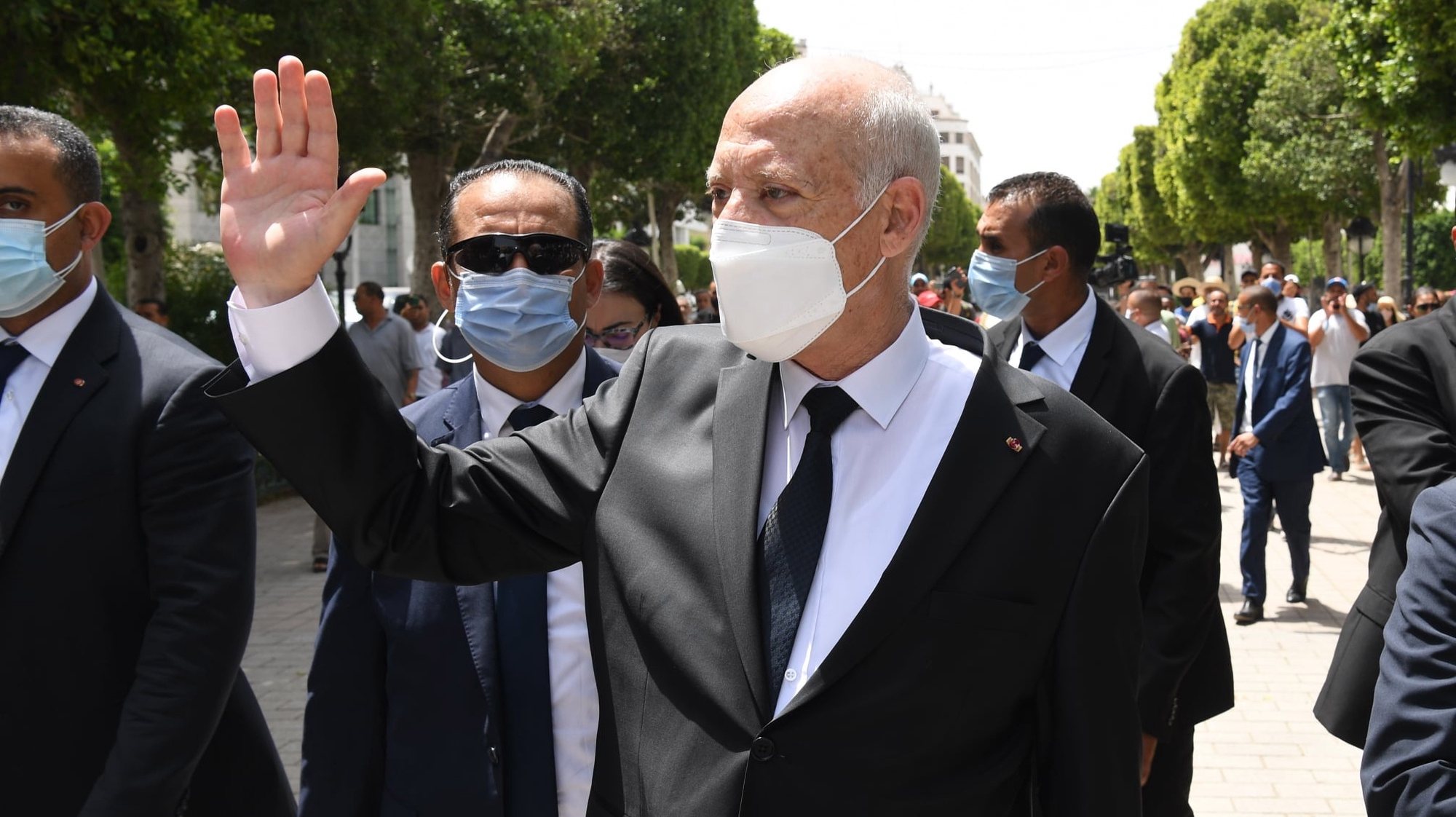 epa09386128 A handout photo made available by the Tunisian Presidency shows Tunisian President Kais Saied gesturing among supports as he walks protected by security guards in Habib Bourguiba Avenue, Tunis, Tunisia, 01 August 2021. Two Members of the Parliament were reportedly arrested on 01 August brining to three the number of MPs detained since Saied sacked prime minister Mechichi and suspended the parliament on 25 July. Saied said he acted within the constitution as US Secretary of State Antony Blinken called for the return &#039;to the democratic path&#039; in the country.  EPA/PRESIDENCY OF TUNISIA HANDOUT  HANDOUT EDITORIAL USE ONLY/NO SALES