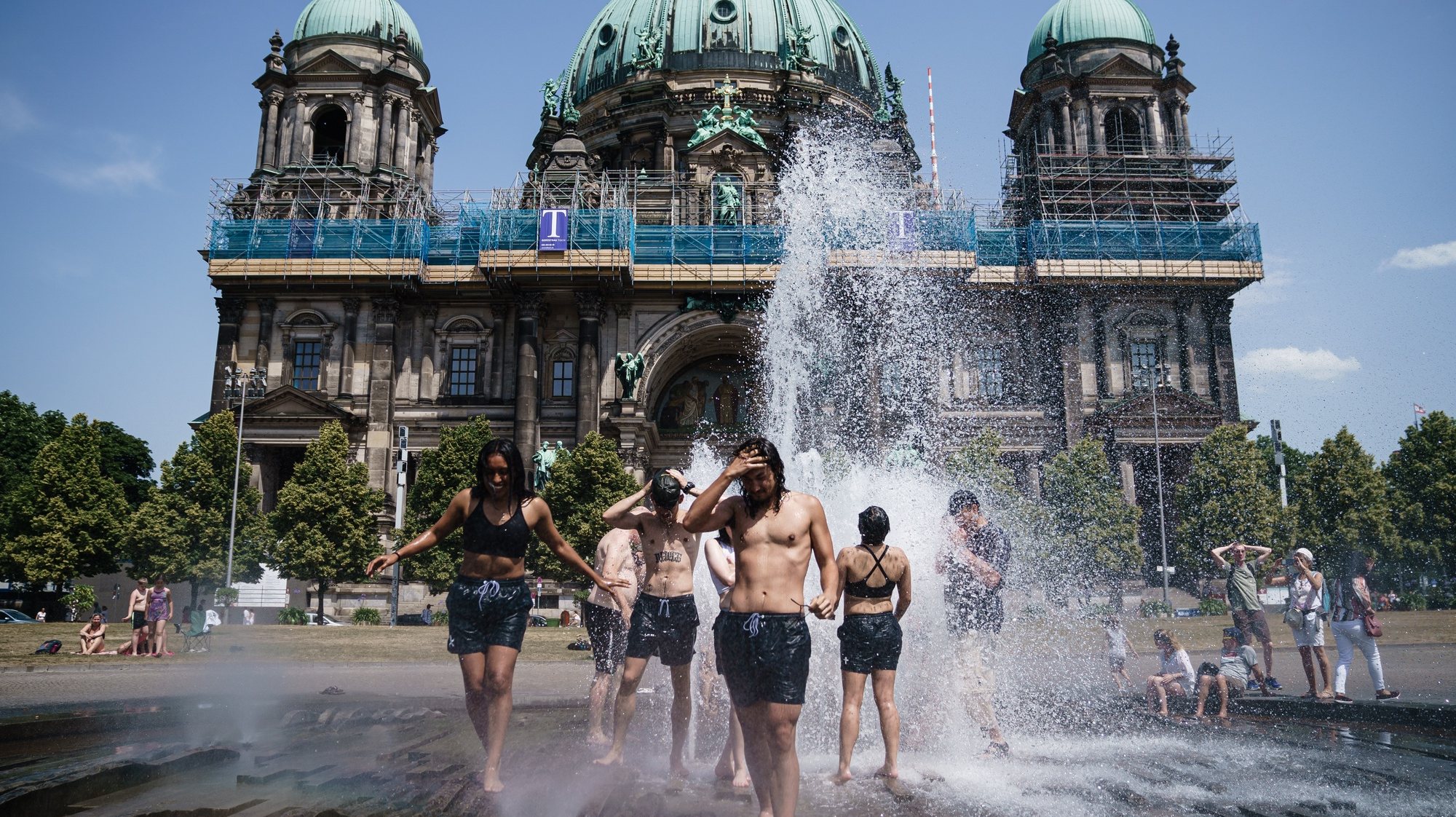 epa10022118 Tourists from the United States cool off in a fountain at Lustgarten park in Berlin, Germany, 19 June 2022. The German Weather Service (Deutscher Wetterdienst) warns of an early heatwave with highs of 38 degrees Celsius in Germany.  EPA/CLEMENS BILAN