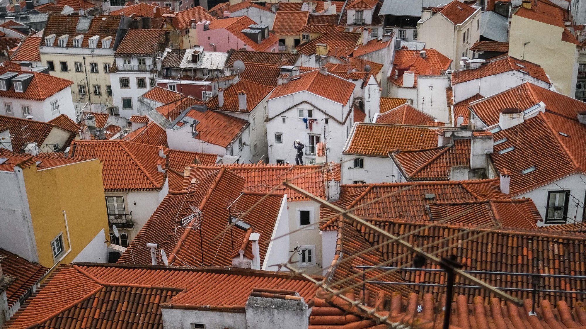 epa09282366 A man works on a roof at Bairro de Alfama in Lisbon, Portugal, 18 June 2021. TheÂ Portuguese cabinetÂ announced on 17 June the ban on circulation to and from the Lisbon Metropolitan Area (AML) on weekends, starting at 15:00 on 18 June, due to the rise in cases ofÂ Covid-19 in this territory.  EPA/MARIO CRUZ