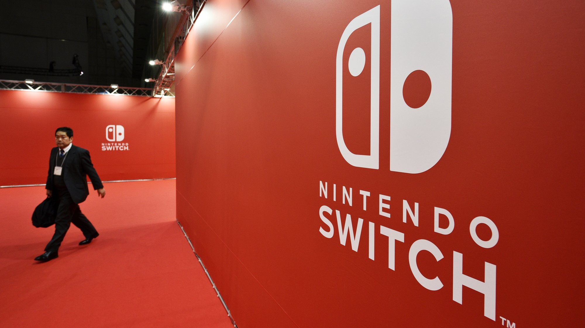 epa09180302 (FILE) - A man walks past the Nintendo Switch logo during the Nintendo Switch Presentation 2017 in Tokyo, Japan, 13 January 2017 (reissued 06 May 2021). On 06 May 2021, Nintendo Co. announced that its consolidated financial results for the fiscal year ended March 2021 reached a record high with net income of 4.4 billion USD, up 85.7 percent from the previous year thanks to strong sales of its Switch game console.  EPA/FRANCK ROBICHON