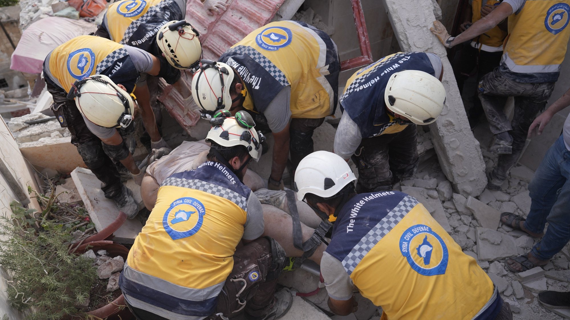 epa10907266 Members of the Syrian civil defense evacuate a man from a damaged building after an attack by Syrian forces against a neighborhood in Idlib, Syria, 08 October 2023. According to the UK-based Syrian Observatory for Human Rights (SOHR), at least four people were killed in a rocket strike reportedly carried by government forces on residential neighborhoods in the center of Idlib city. According to the White Helmets, the Syria Civil Defence organization operating in northwestern Syria, the death toll of attacks targeting opposition-controlled Aleppo countryside and Idlib since 05 October increased to at least 41 people.  EPA/YAHYA NEMAH