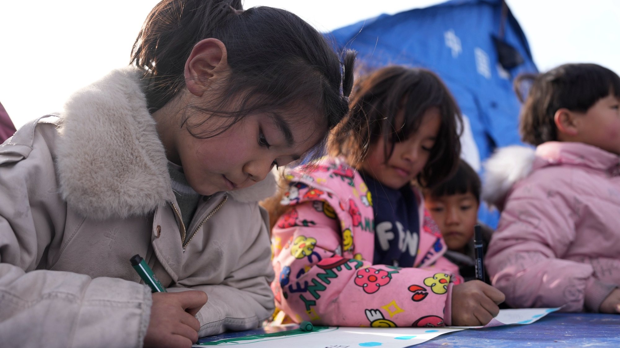 epa11040932 Children work on their drawings at a temporary relocation site in Dahejia Township, Jishishan County, northwest China&#039;s Gansu Province, 22 December 2023. After a 6.2-magnitude earthquake hit Gansu Province on 18 December 2023, volunteers and psychotherapists started to provide quake-affected children at the temporary relocation site with voluntary classes, including activities such as drawing, games, tutoring, etc.  EPA/XINHUA / Fang Xin CHINA OUT / UK AND IRELAND OUT  /       MANDATORY CREDIT  EDITORIAL USE ONLY  EDITORIAL USE ONLY