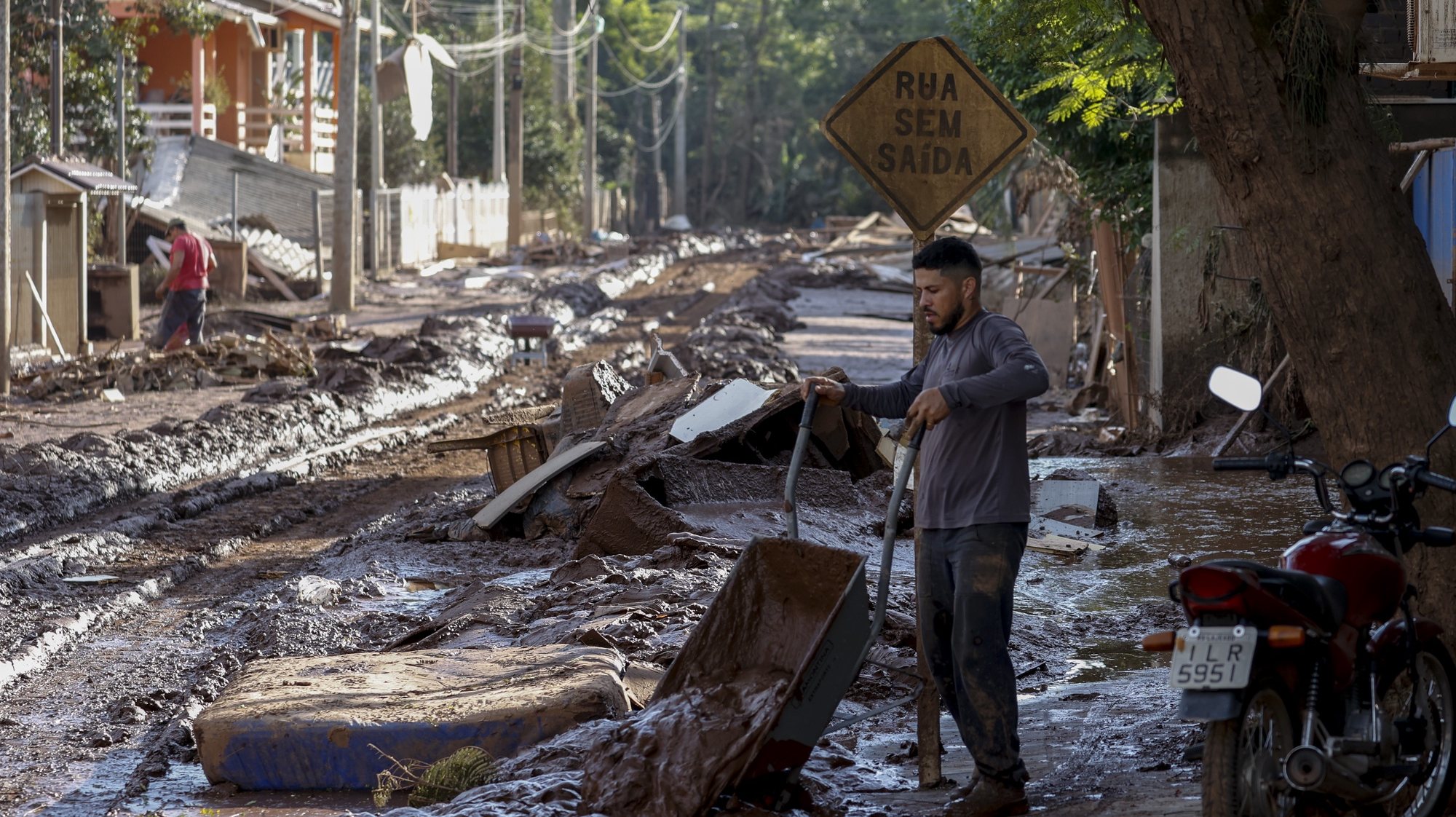 epaselect epa11327657 A man removes the mud that flooded his house after the Taquari river overflowed its banks in Cruzeiro do Sul, Rio Grande do Sul state, Brazil, 08 May 2024. The death toll from catastrophic floods in southern Brazil has exceeded 100, according to the latest figures released by the Civil Defense on 08 May.  EPA/SEBASTIAO MOREIRA
