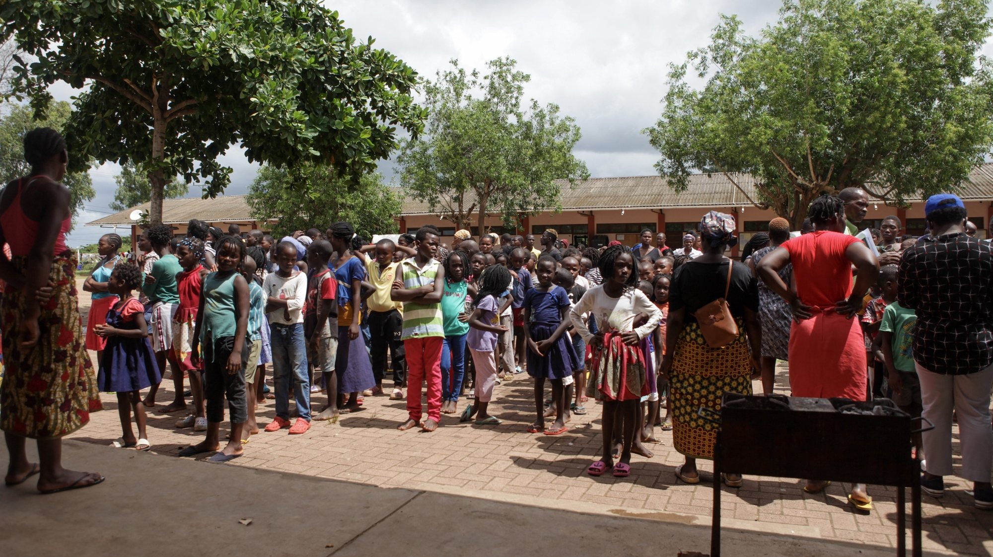 Crianças em fila esperam para serem identificadas no centro de acolhimento de desalojados das cheias em Moçambique na Escola Secundária Joaquim Chissano, no município de Boane, província de Maputo, Moçambique, 14 de fevereiro de 2023. (ACOMPANHA TEXTO DE 15-02-2023) LUISA NHANTUMBO/LUSA