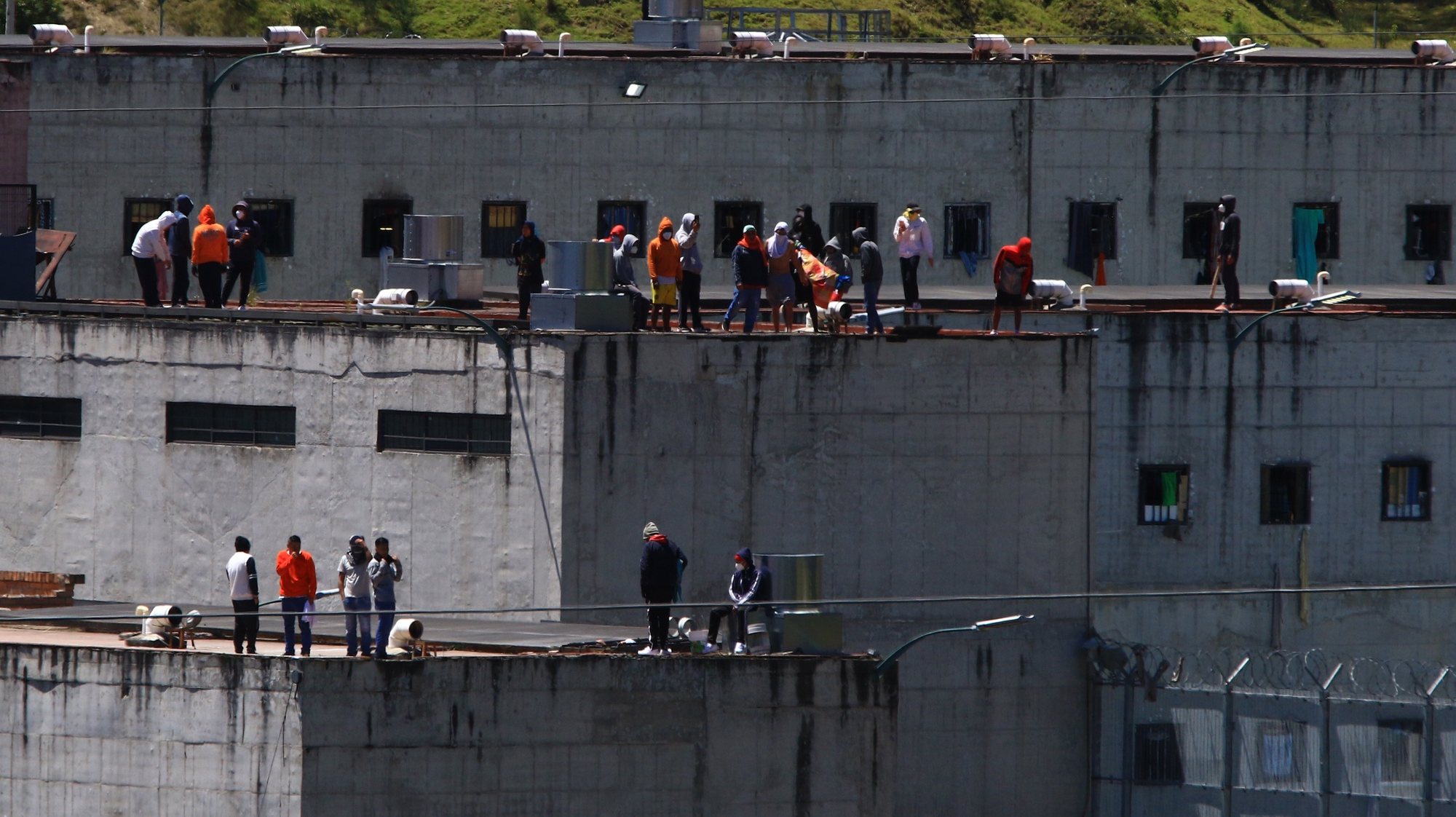 epa10829698 Prisoners on the roofs of El Turi prison, in the city of Cuenca, Ecuador, 30 August 2023. Prisoners from Cuenca and Azogues jails rioted in protest against the intervention of the Police and the Armed Forces in the Latacunga prison, as part of a series of operations being carried out to seize weapons in prisons, in the framework of a state of emergency decreed by the government.  EPA/Robert Puglla