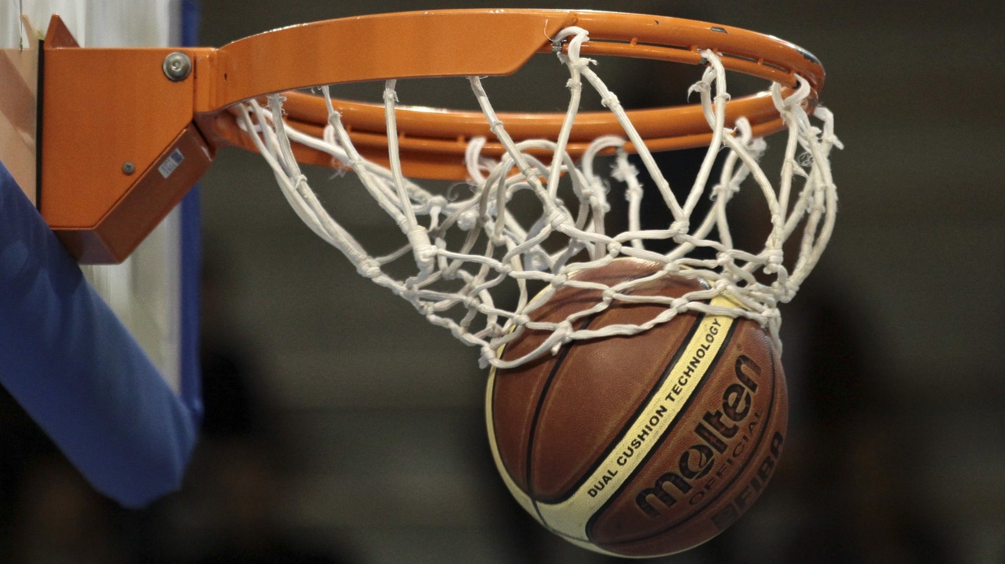 Bola entra no cesto durante um jogo de basquetebol