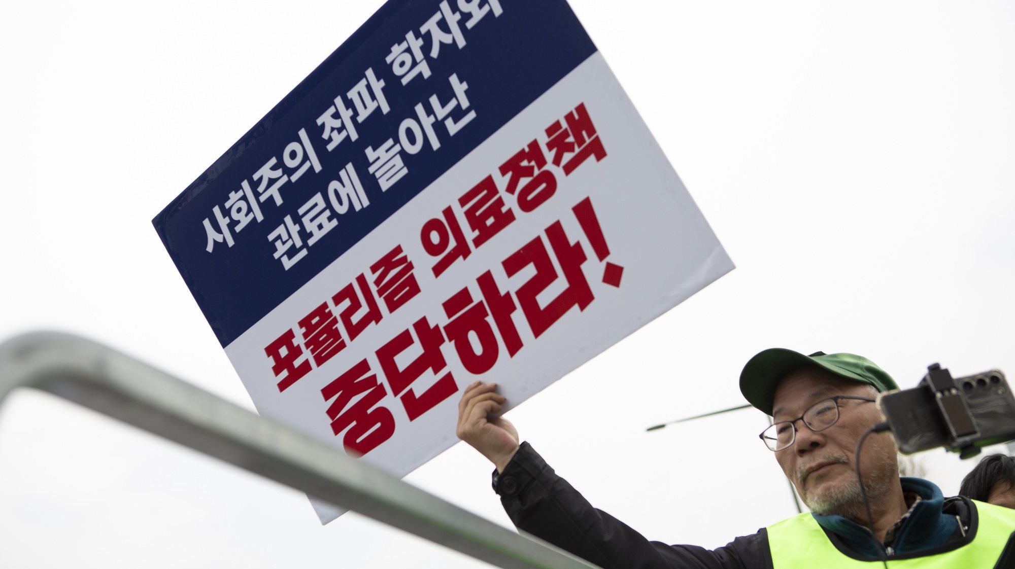 epa11186116 A Doctor of Gyonggi-do medical association holds a sign reading &#039;Stop Populism medical policy&#039;, during a protest against the government&#039;s medical policy, near the presidential office in Seoul, South Korea, 28 February 2024. South Korean hospitals earlier in February turned away patients and delayed surgeries, amid spiking tensions between doctors and the government over the latter&#039;s plan to increase the number of medical students. More than half of the country&#039;s 13,000 trainee doctors submitted their resignations on 20 February in protest of the plan, citing pay and overworking conditions.  EPA/JEON HEON-KYUN