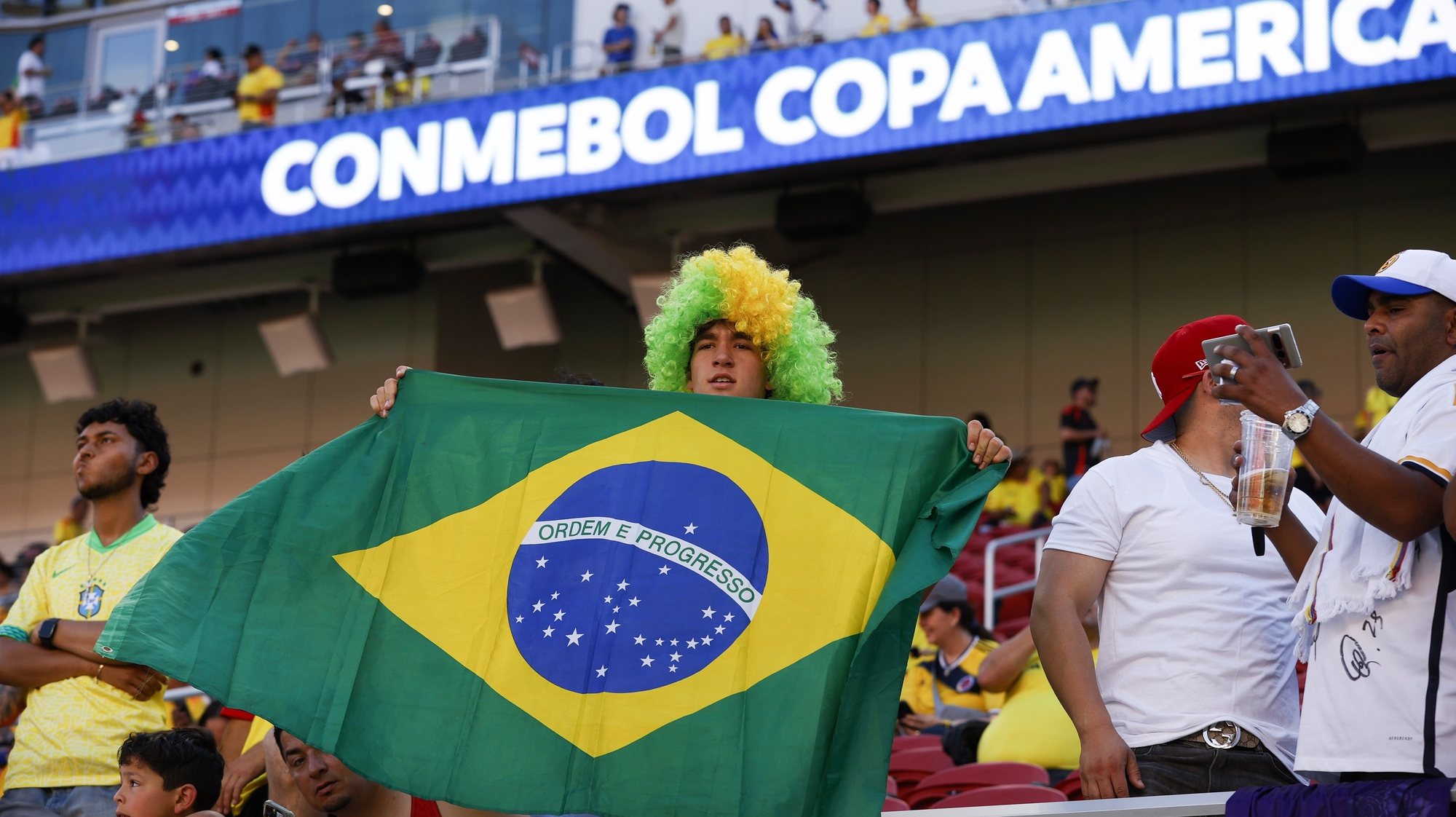 epa11453947 A Brazil fans holds up a Brazilian flag before the start of the CONMEBOL Copa America 2024 group D soccer match between Brazil and Colombia, in Santa Clara, California, USA, 02 July 2024.  EPA/JOHN G. MABANGLO