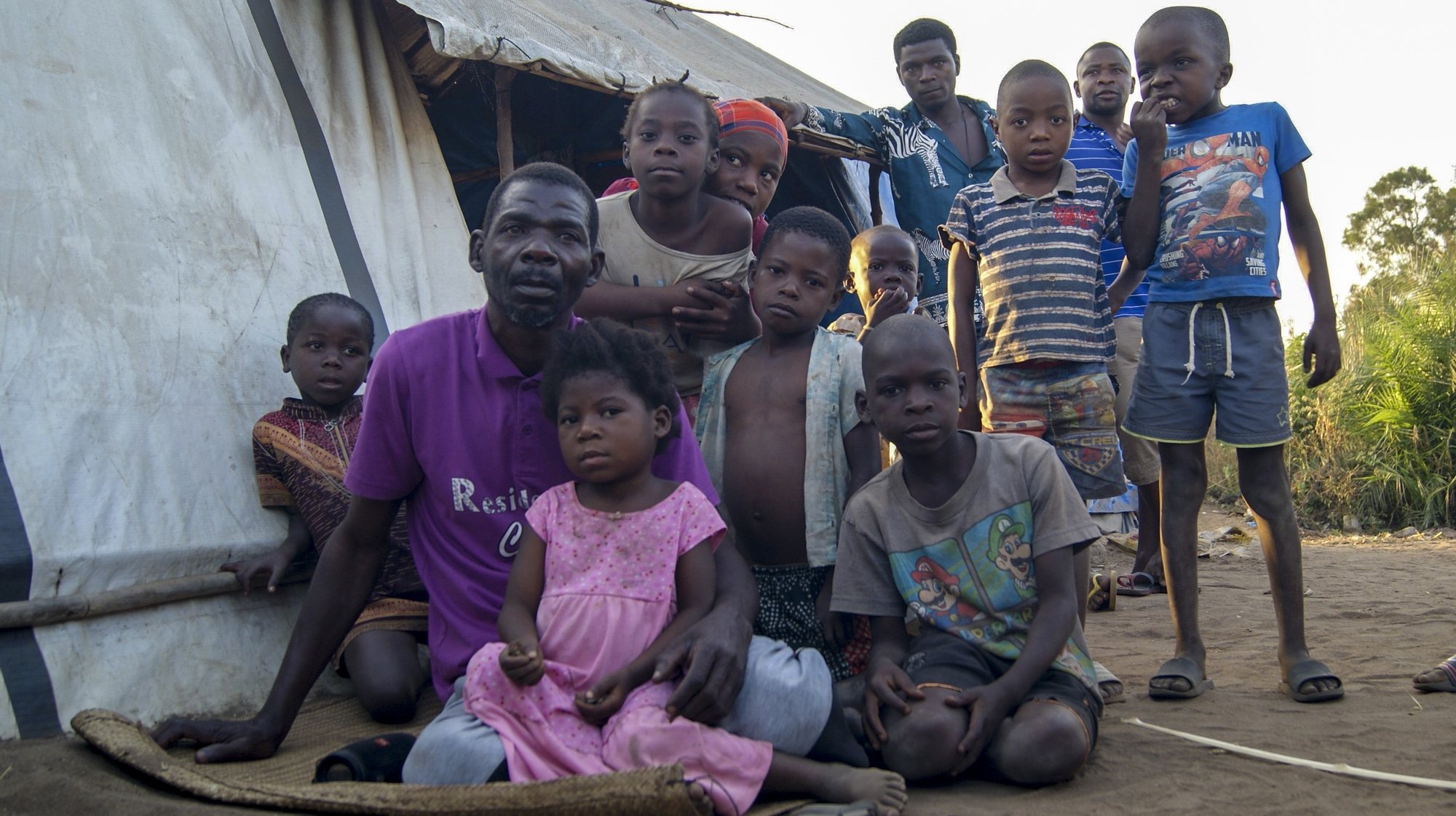 Abu Sefo (2-E), 52 anos, fugiu de Mocímboa da Praia há um ano com sua família, posa para a fotografia acompanhado por crianças num dos campos de acolhimento de deslocados em Metuge, espaço que alberga deslocados que fogem da violência armada no norte de Moçambique, Cabo Delgado, Moçambique, 16 de agosto de 2021. Na sequência dos ataques, que aterrorizam a província de Cabo Delgado desde 2017, há mais de 3.100 mortes, segundo o projeto de registo de conflitos ACLED, e mais de 817 mil deslocados, segundo as autoridades moçambicanas. (ACOMPANHA TEXTO DA LUSA DO DIA 17 DE AGOSTO DE 2021). LUÍSA NHANTUMBO/LUSA