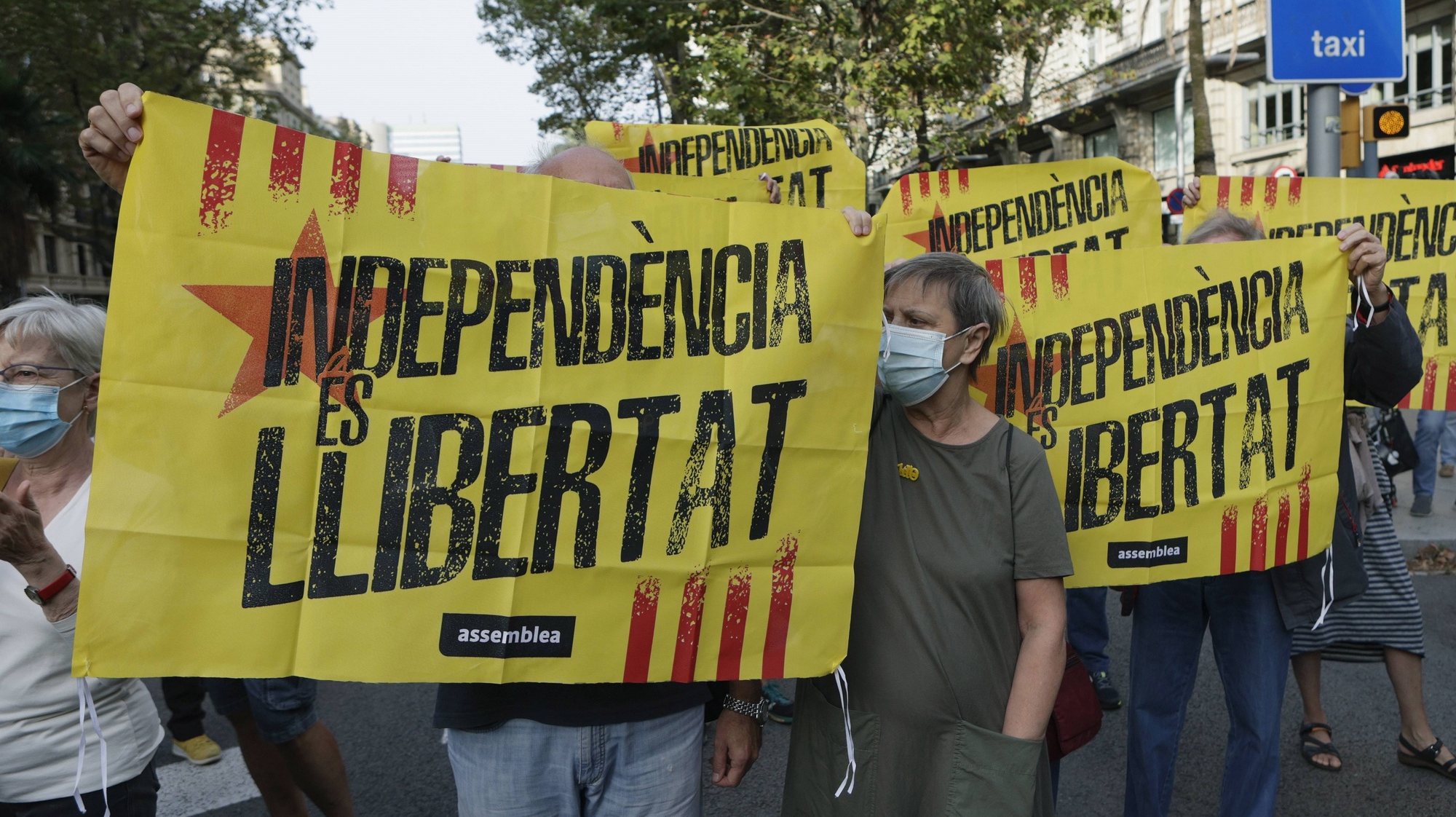 epa09484802 Demonstrators hold a banner reading in Catalan language &#039;Independence is Freedom&#039; as several dozens people rally in front of Italian Consulate to protest against the arrest of Catalan pro-independent leader and former regional President Carles Puigdemont in the Italian island of Sardinia 23 September evening, in Barcelona, Spain, 24 September 2021. Puigdemont was arrested under a international warrant asked by Spanish authorities, four years after he run away from judicial authorities amid the inquiry of the illegal referendum held in Catalonia in 2017.  EPA/QUIQE GARCIA