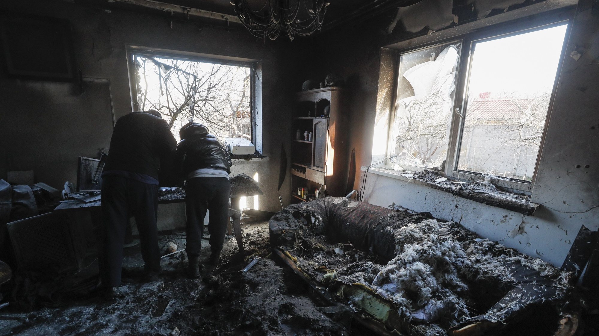epa09826086 People stand inside a damaged apartment following an overnight shelling on a holiday village in the Osokorky district, outskirts of Kyiv (Kiev), Ukraine, 15 March 2022. Kyiv authorities announced a 35-hour curfew from 8 p.m. on 15 March until 7 a.m. on 17 March after a number of residential buildings in the capital were hit during early morning Russian air strikes.  EPA/SERGEY DOLZHENKO