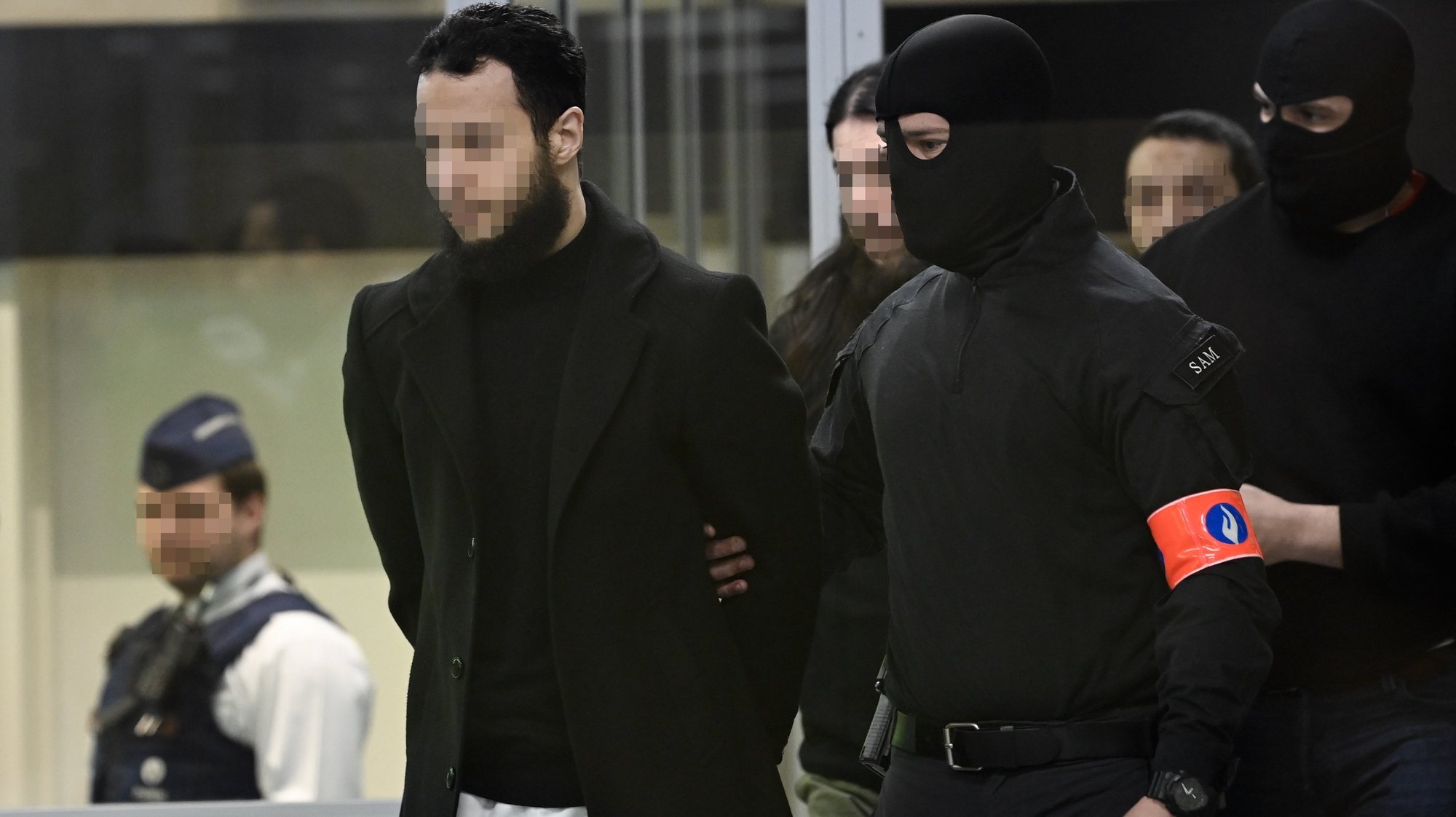 epa10556588 Defendants Salah Abdeslam, Osama Krayem and Mohamed Abrini are escorted by police as they arrive in court during the trial of the 2016 Brussels terror attacks at the Justitia building in Brussels, Belgium, 03 April 2023. Nine defendants are on trial over the March 22, 2016, bomb attacks at Brussels&#039; Zaventem airport and Maelbeek metro station, that killed 32 people, and which were claimed by the Islamic State (IS) extremist group.  EPA/JOHN THYS / POOL  ATTENTION EDITORS: Faces pixelated at source  MAXPPP OUT