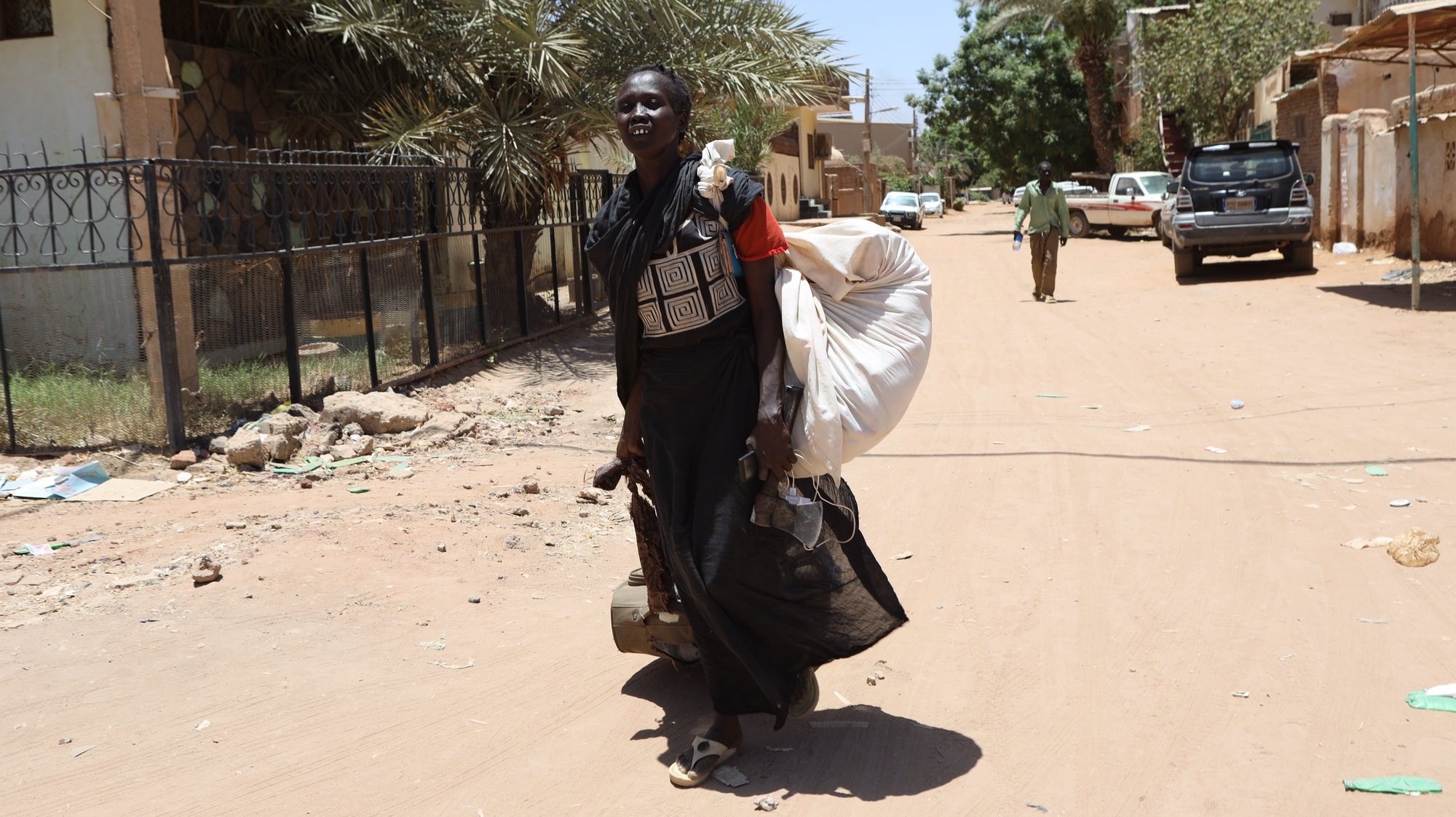 epa10579958 A Sudanese woman carries her belongings on a street in Khartoum, Sudan, 19 April 2023. A power struggle erupted since 15 April between the Sudanese army led by army Chief General Abdel Fattah al-Burhan and the paramilitaries of the Rapid Support Forces (RSF) led by General Mohamed Hamdan Dagalo, resulting in at least 200 deaths according to doctors&#039; association in Sudan.  EPA/STRINGER