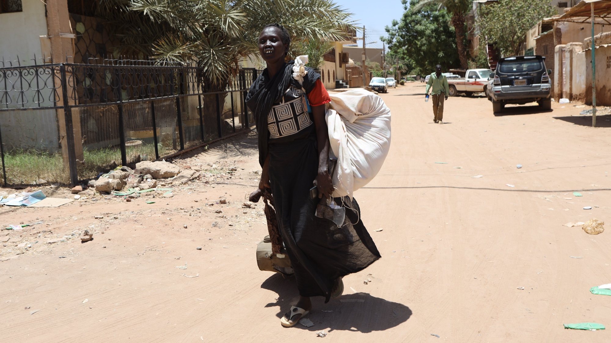 epa10579958 A Sudanese woman carries her belongings on a street in Khartoum, Sudan, 19 April 2023. A power struggle erupted since 15 April between the Sudanese army led by army Chief General Abdel Fattah al-Burhan and the paramilitaries of the Rapid Support Forces (RSF) led by General Mohamed Hamdan Dagalo, resulting in at least 200 deaths according to doctors&#039; association in Sudan.  EPA/STRINGER
