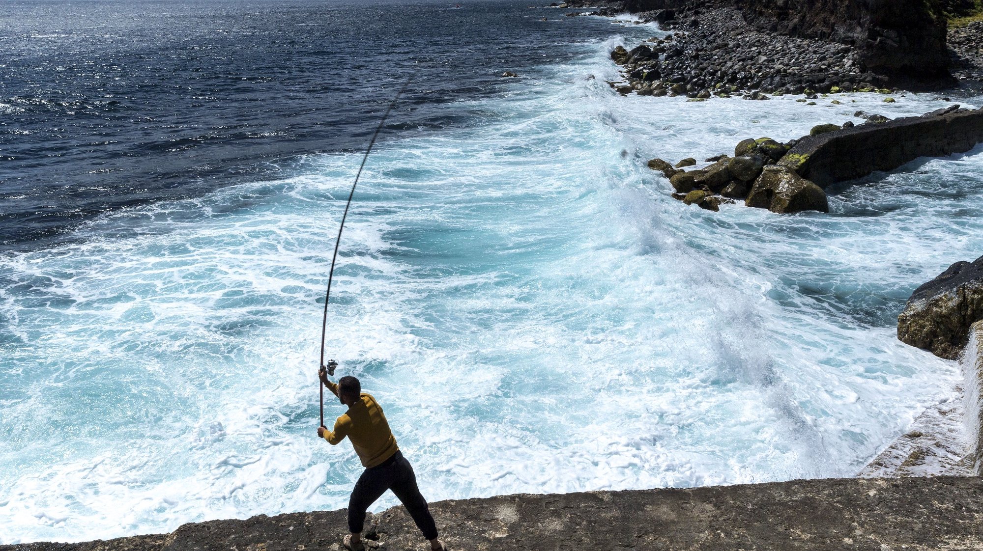 Um popular pesca numa praia do concelho do Nordeste, Ilha de São Miguel, Açores, 18 de maio de 2020.  O concelho do Nordeste foi último do país a sair da cerca sanitária por causa da covid-19. EDUARDO COSTA /LUSA