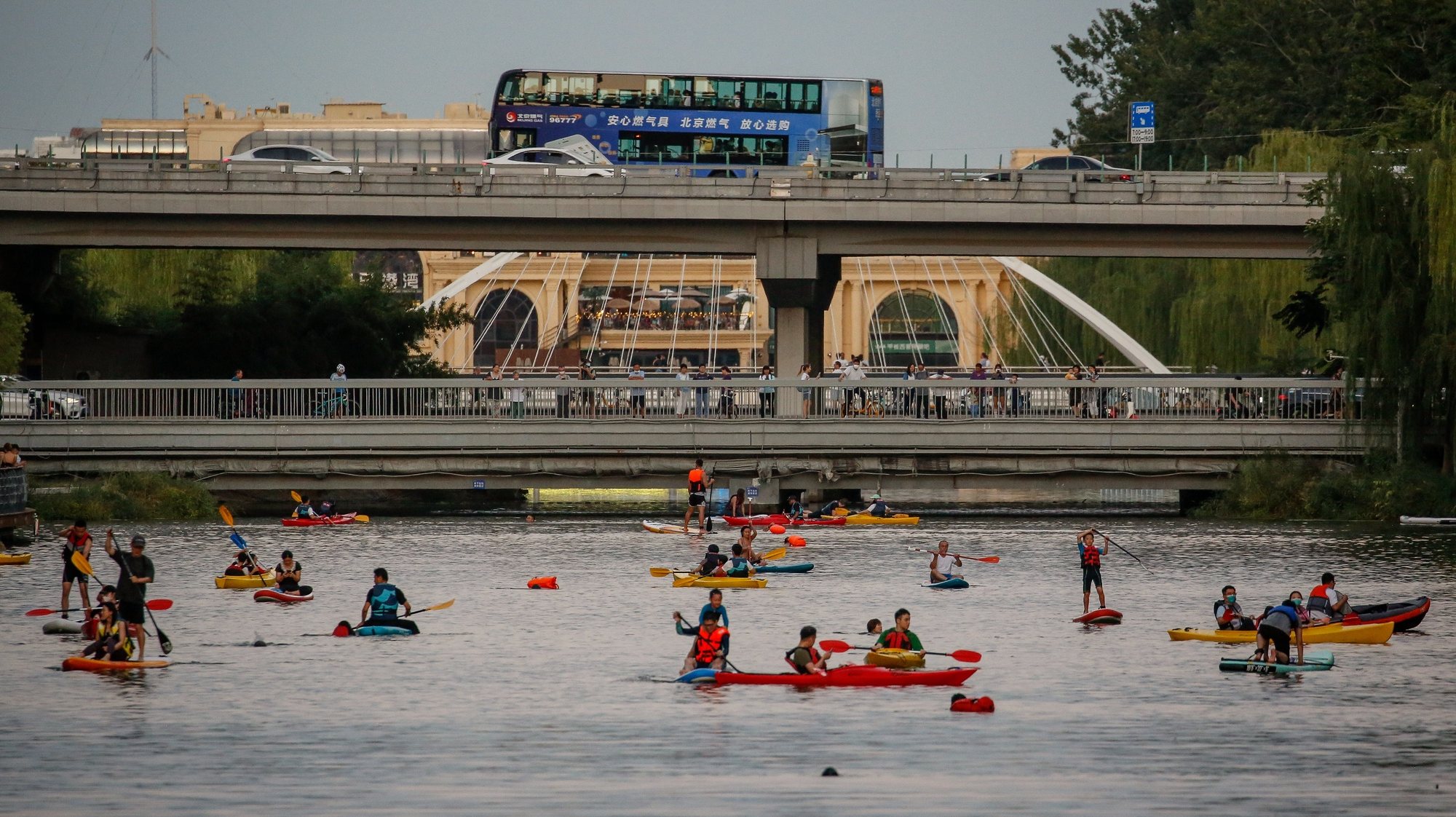 epa10191578 People ride paddle boards and kayaks at the Liangma river in Beijing, China, 18 September 2022. After more than two weeks in lockdown, local authorities announced relaxing of curbs starting 19 September in Chengdu, southwestern China.  EPA/MARK R. CRISTINO