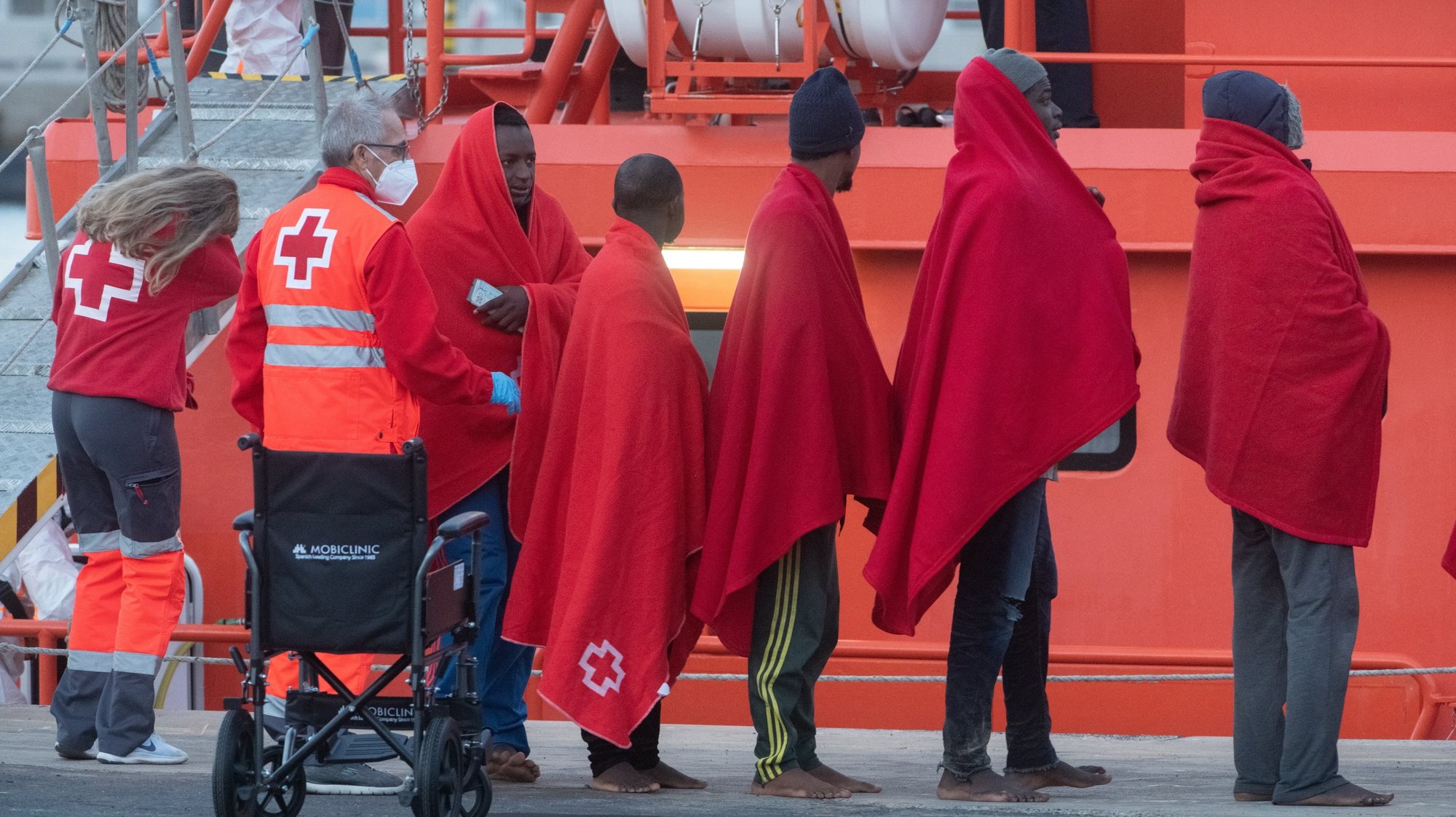 epa10992168 Spanish Red Cross members assist a group of 141 migrants upon arrival in the Puerto del Rosario port, in Fuerteventura Island, Canary Islands, southwestern Spain, 24 November 2023. A total of 289 migrants were rescued in the area last night, 141 arrived in Fuerteventura Island, 66 migrants moved to Gran Tarajal in Fuerteventura, and another 82 moved to Gran Canaria island.  EPA/Carlos de Saa