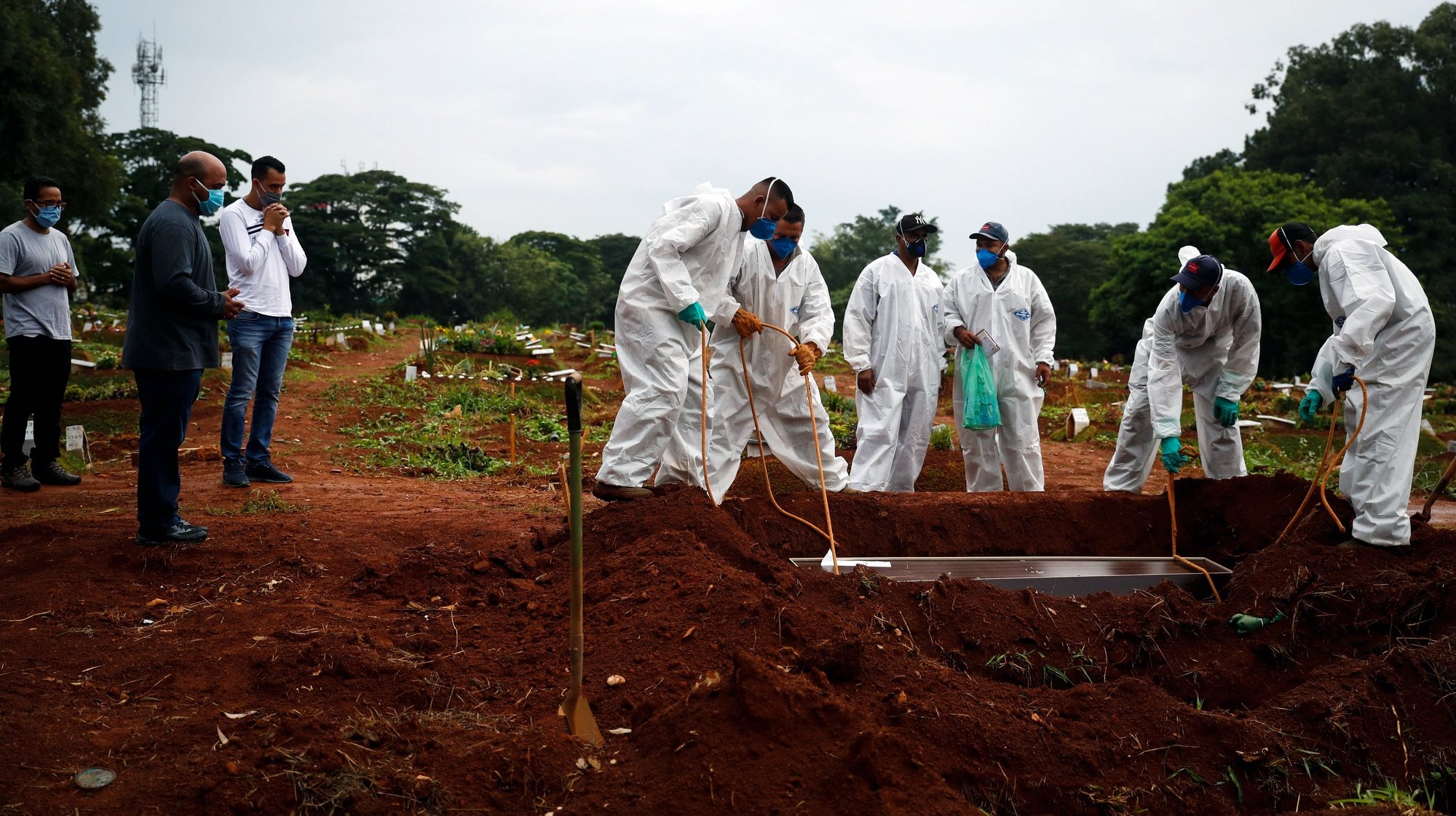 epa09081869 Workers bury a Covid-19 victim at the Viola Formosa Cemetery in Sao Paulo, Brazil, 18 March 2021. Brazil registered a new daily record of 90,303 Covid-19 infections on 17 March 2021 adding to the more than 11.6 million cases. Deaths were also high in the last 24 hours, with 2,648 deaths from the virus, the second highest figure after the record 2,841 deaths registered on 16 March bringing Brazil to close to 285,000 victims, according to the bulletin released by the Ministry Health.  EPA/Fernando Bizerra Jr