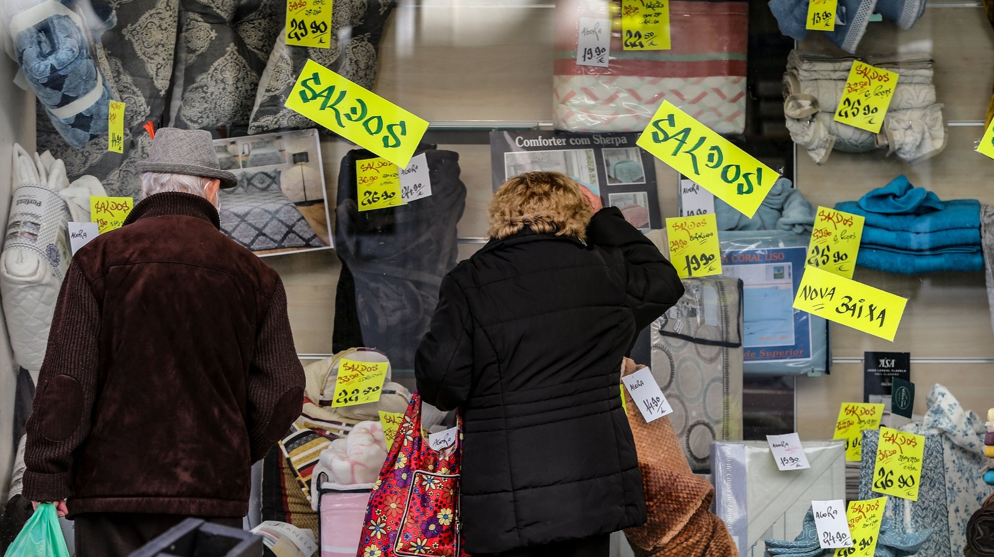 Populares observam as montras das lojas após a reabertura de comércio não-essencial e cabeleireiros fechado anteriormente após novo decreto do Estado de Emergência devido à covid-19, Lisboa, 15 março 2021.  MANUEL DE ALMEIDA / LUSA