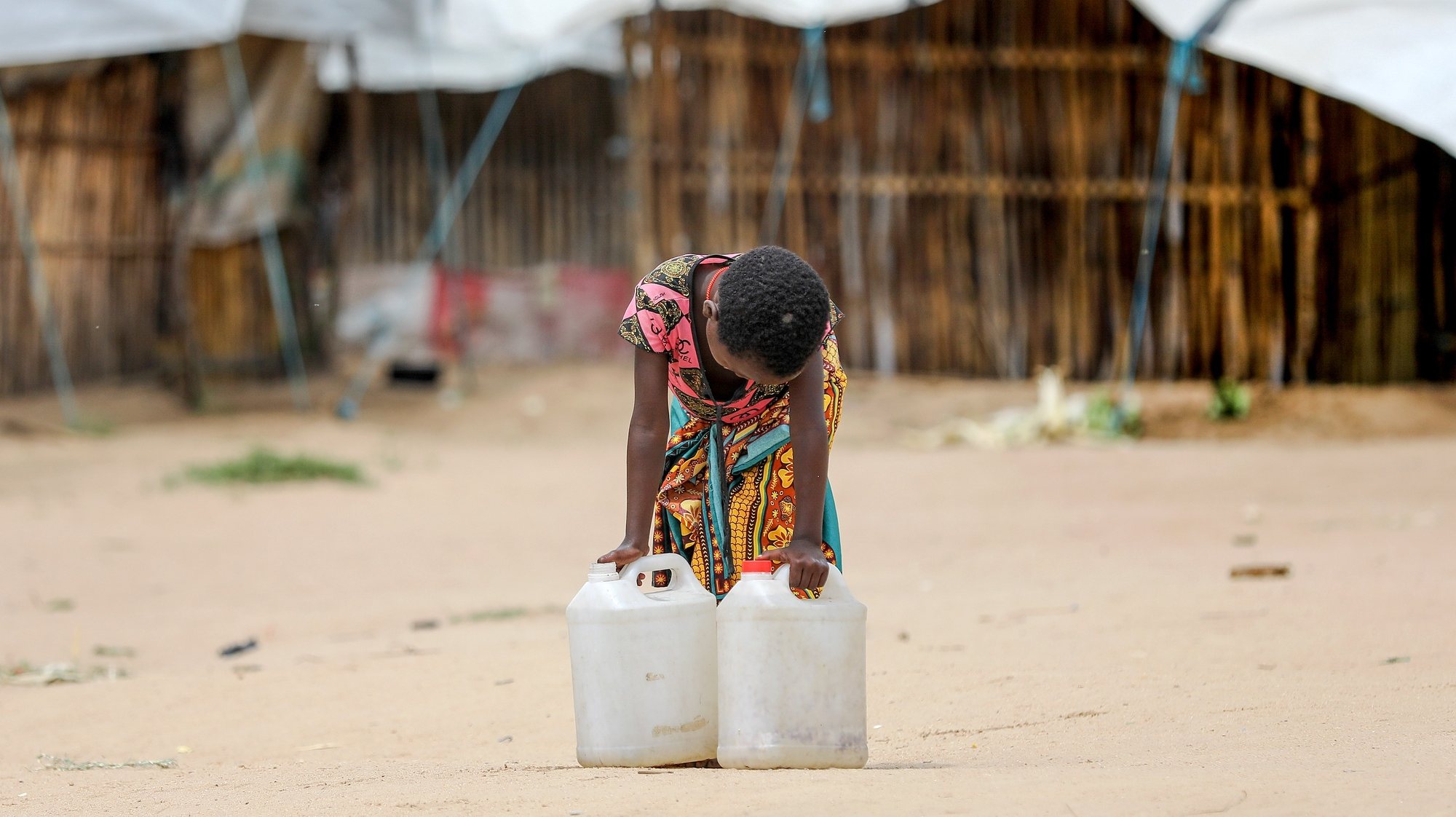 A young displaced girl carrying water bidons in the 25 June relocated camp in Belibize, near Metuge, northern Mozambique, 10 April 2021. The violence unleashed more than three years ago in Cabo Delgado province escalated again about two weeks ago, when armed groups first attacked the town of Palma. JOAO RELVAS/LUSA