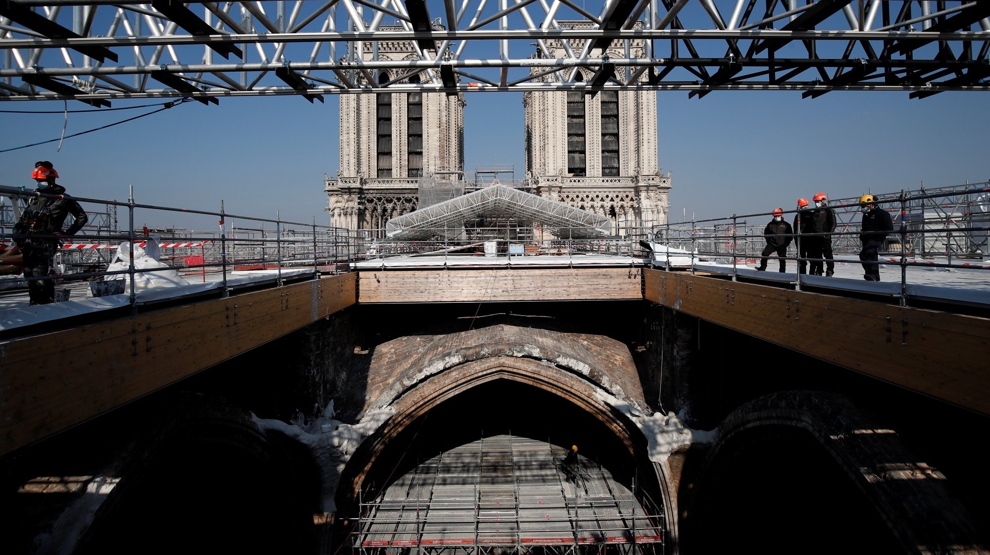 epa09136441 Workers watch the ongoing works at the reconstruction site of the Notre-Dame de Paris Cathedral, which was damaged in a devastating fire two years ago, as restoration works continue, in Paris, France, 15 April 2021. On 15 April 2019, the structure and roof of the 850-year-old gothic Notre-Dame Cathedral suffered a devastating fire. Some 500 firefighters managed to prevent the entire cathedral from being reduced to ashes, although its celebrated spire has been destroyed. French President Emmanuel Macron promised to rebuild the cathedral within five years.  EPA/BENOIT TESSIER / POOL MAXPPP OUT