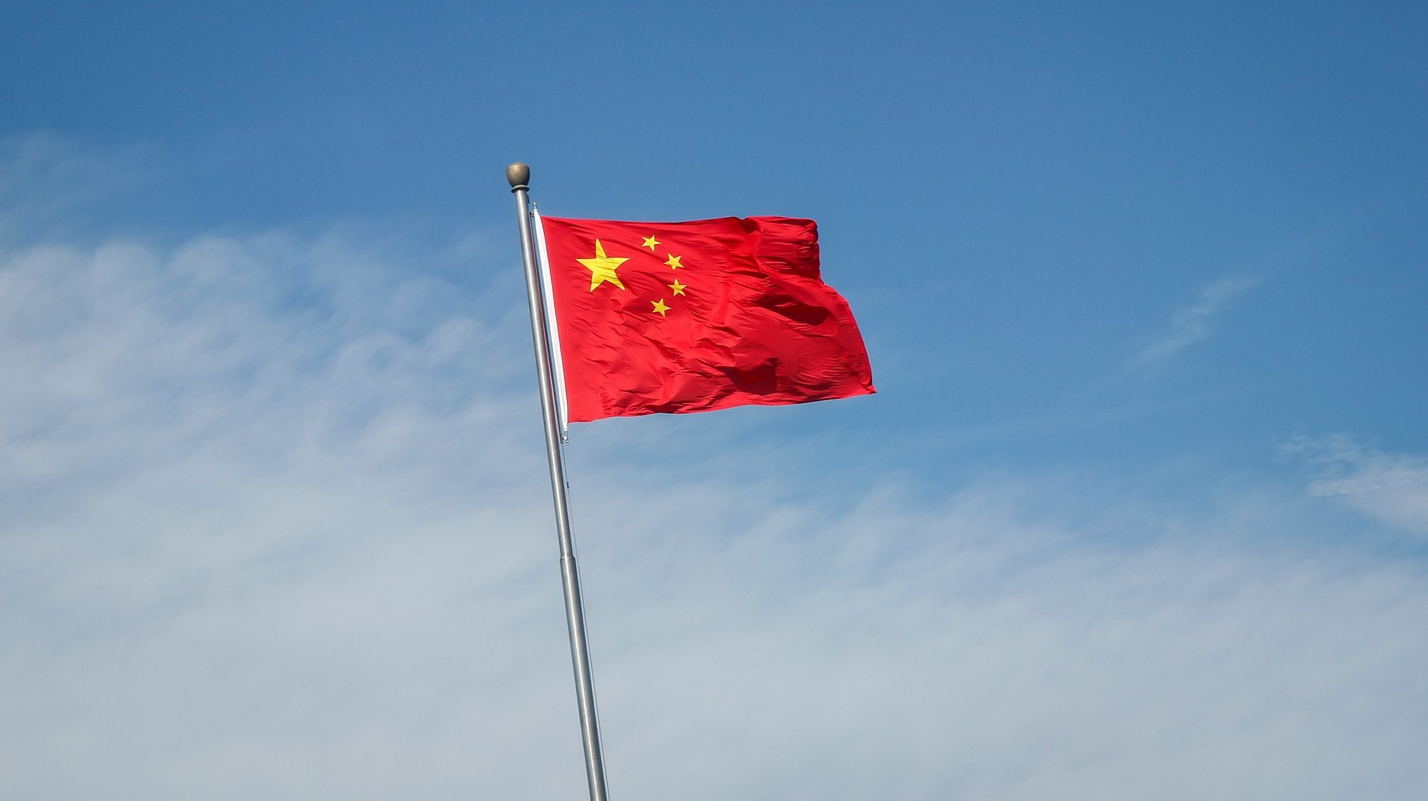 epa10133364 China&#039;s flag flutters along a road in Beijing, China, 22 August 2022. China has cut its benchmark loan rates to help revive its economy. China&#039;s one year loan prime rate was cut from 3.7 percent to 3.65 percent, while the loan rates for mortgages were cut from 4.45 percent to 4.3 percent, the People&#039;s Bank of China (PBOC) said.  EPA/MARK R. CRISTINO
