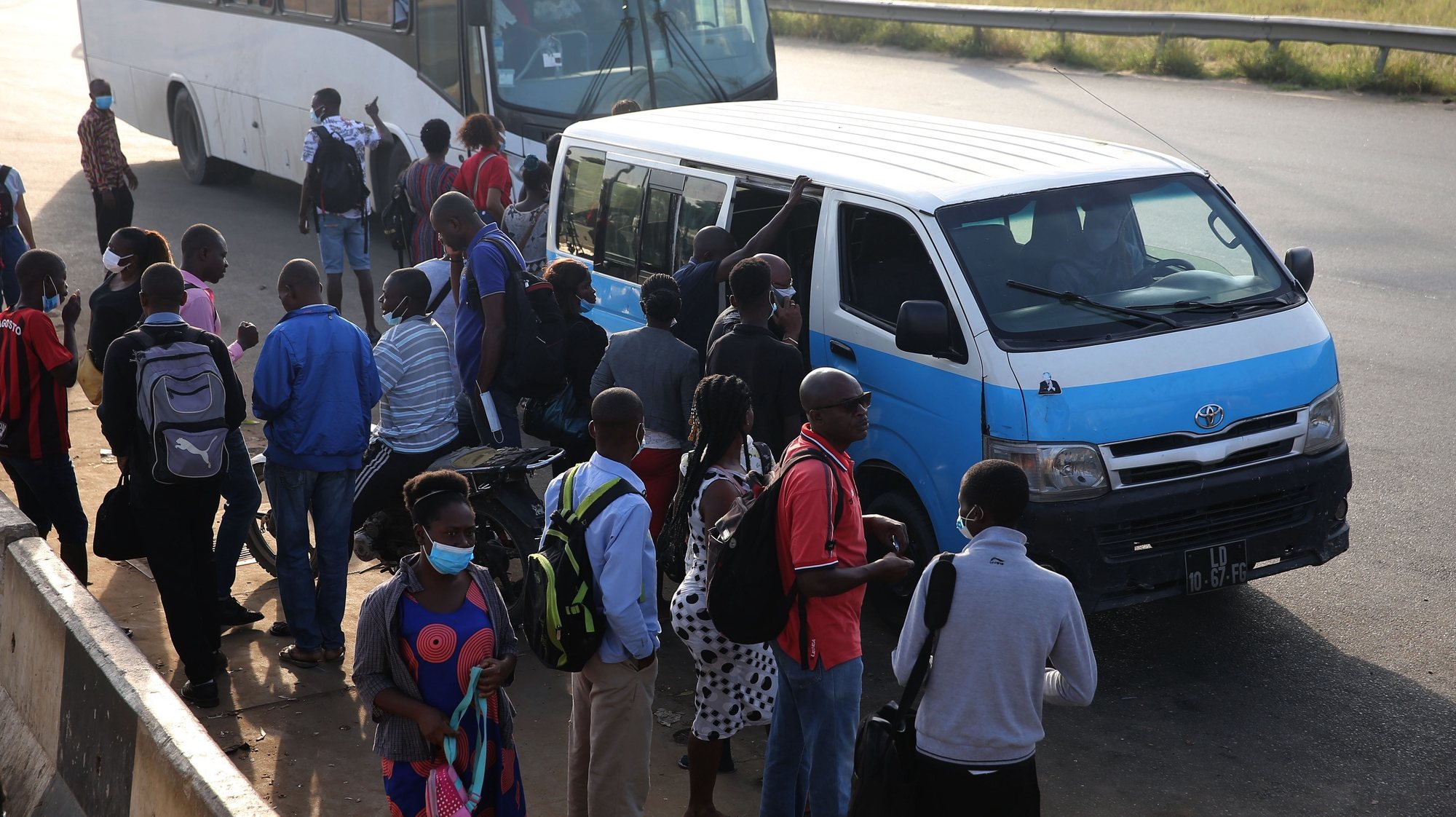 Passageiros entram e saem de um táxi “azuis e brancos” em Luanda, Angola, 21 de janeiro de 2022. Cada “táxi” ou “quadradinho”, normalmente uma pequena carrinha que leva até 15 passageiros, dá emprego a, pelo menos, um motorista, um cobrador e um lotador, nome dado aos jovens que, nas paragens, angariam os clientes e ajudam a “lotar” a viatura. (ACOMPANHA TEXTO DA LUSA DE 22 DE JANEIRO DE 2022). AMPE ROGÉRIO/LUSA