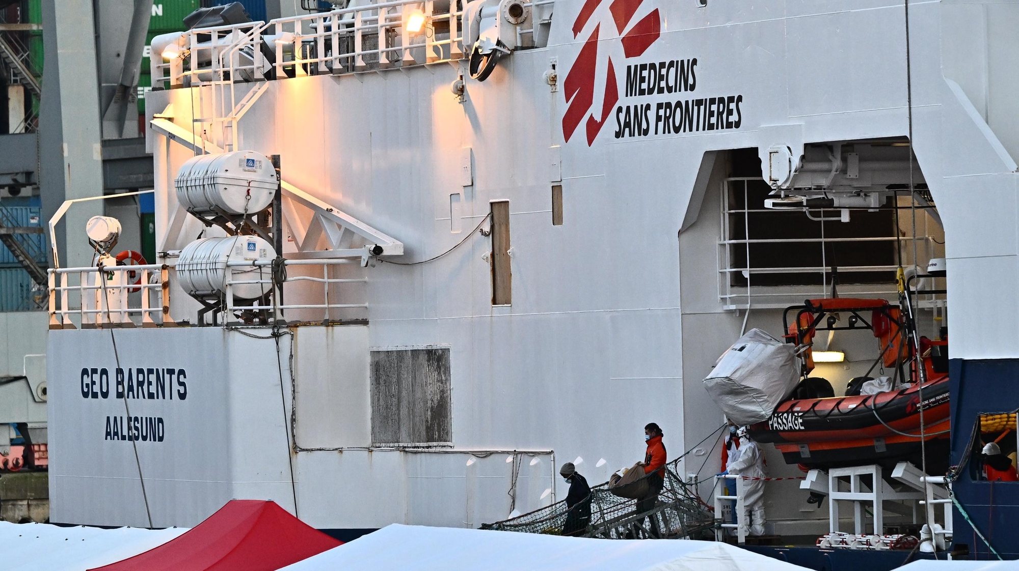 epa10436594 Health officers assist migrants to leave the Geo Barents ship of the MSF docked at the port of La Spezia, Italy, 28 January 2023. Doctors Without Frontiers (MSF) said on 25 January that the Geo Barents conducted its third rescue of the last few days and has 237 asylum seekers on board, adding that 107 people, including 36 minors and five women, were picked up from an overloaded dinghy in the latest operation.  EPA/LUCA ZENNARO